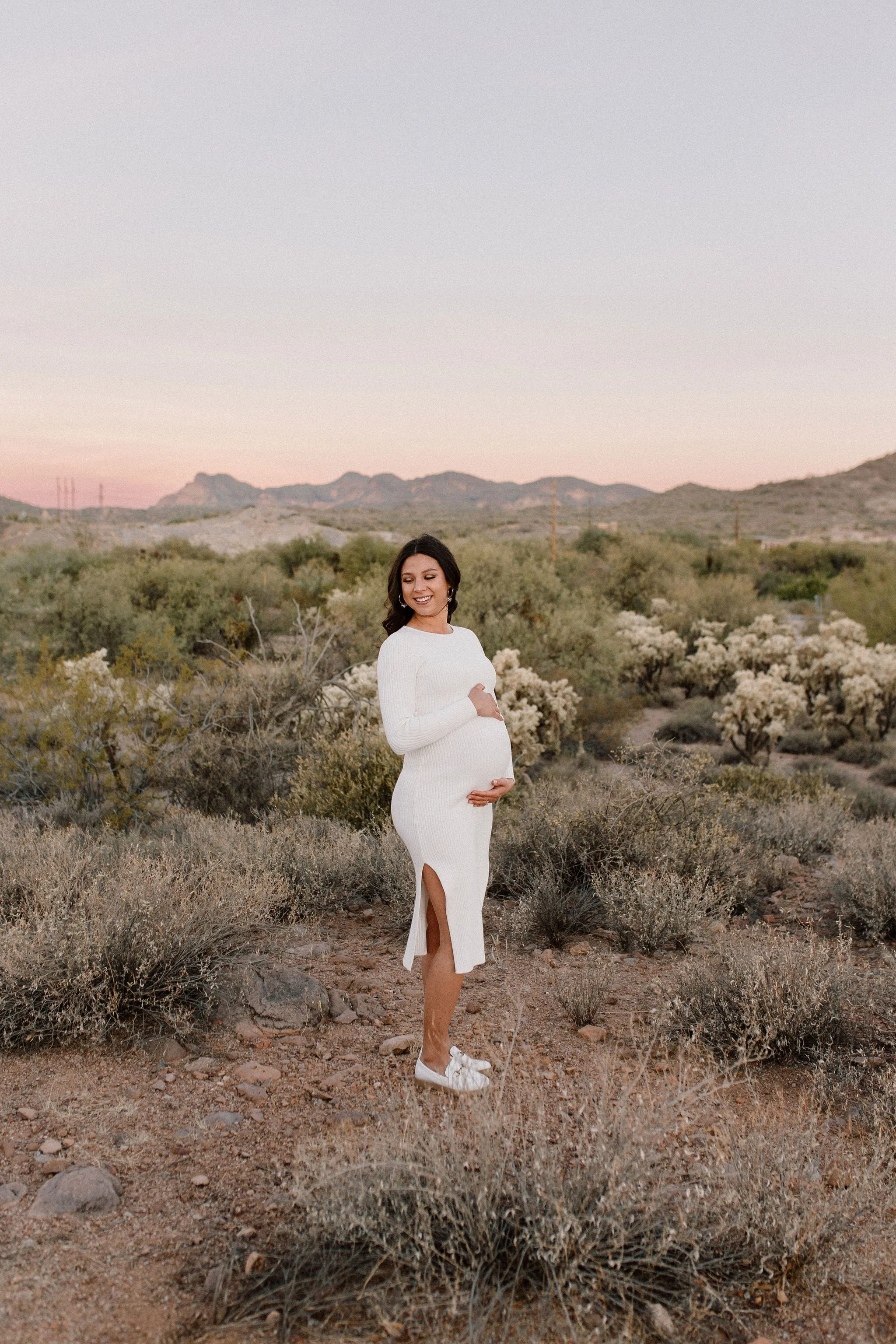 pregnant mom holding belly in desert family maternity pics in Lost Dutchman State Park