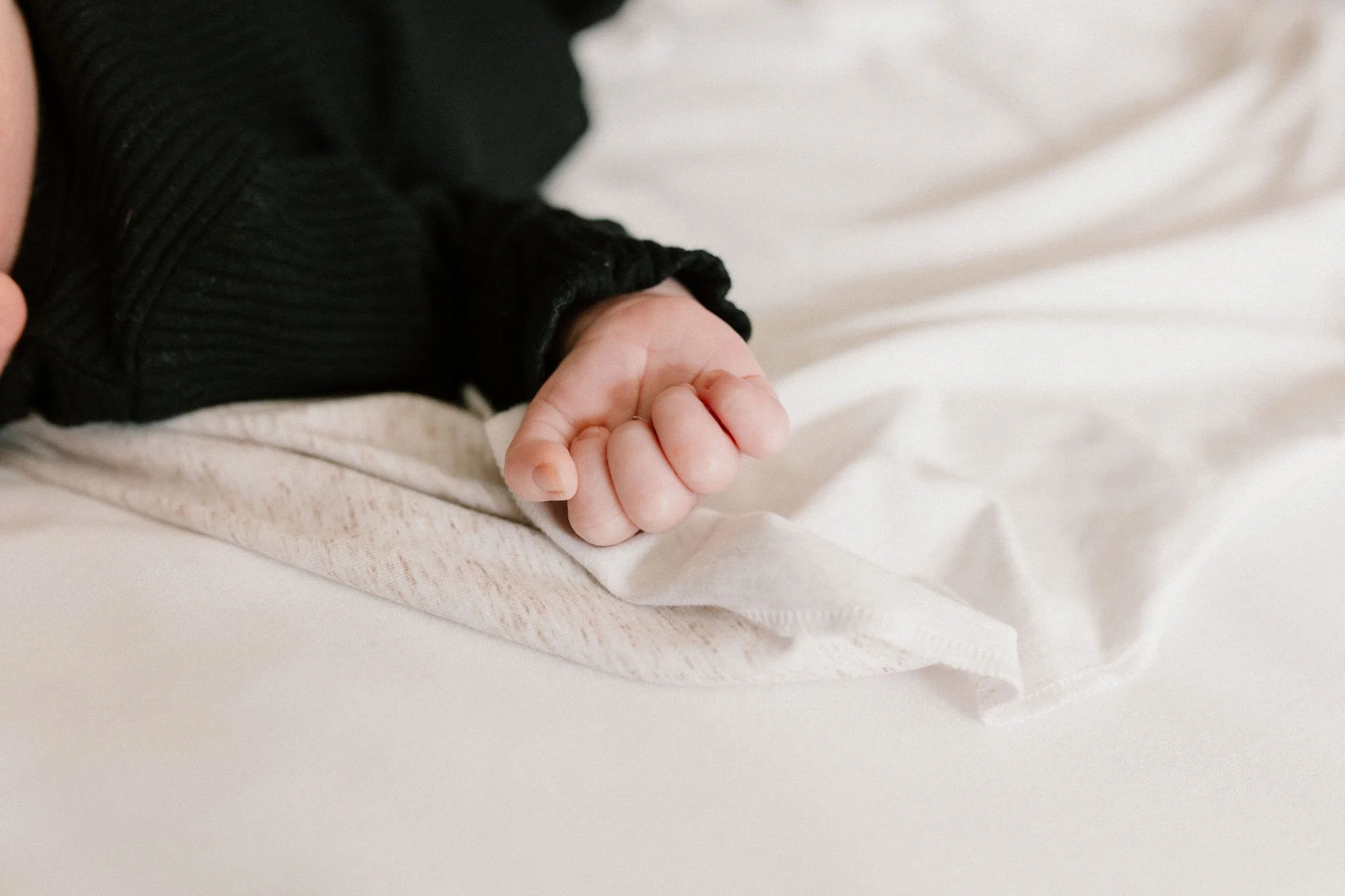 close-up photo of newborn fingers and hand in neutral nursery