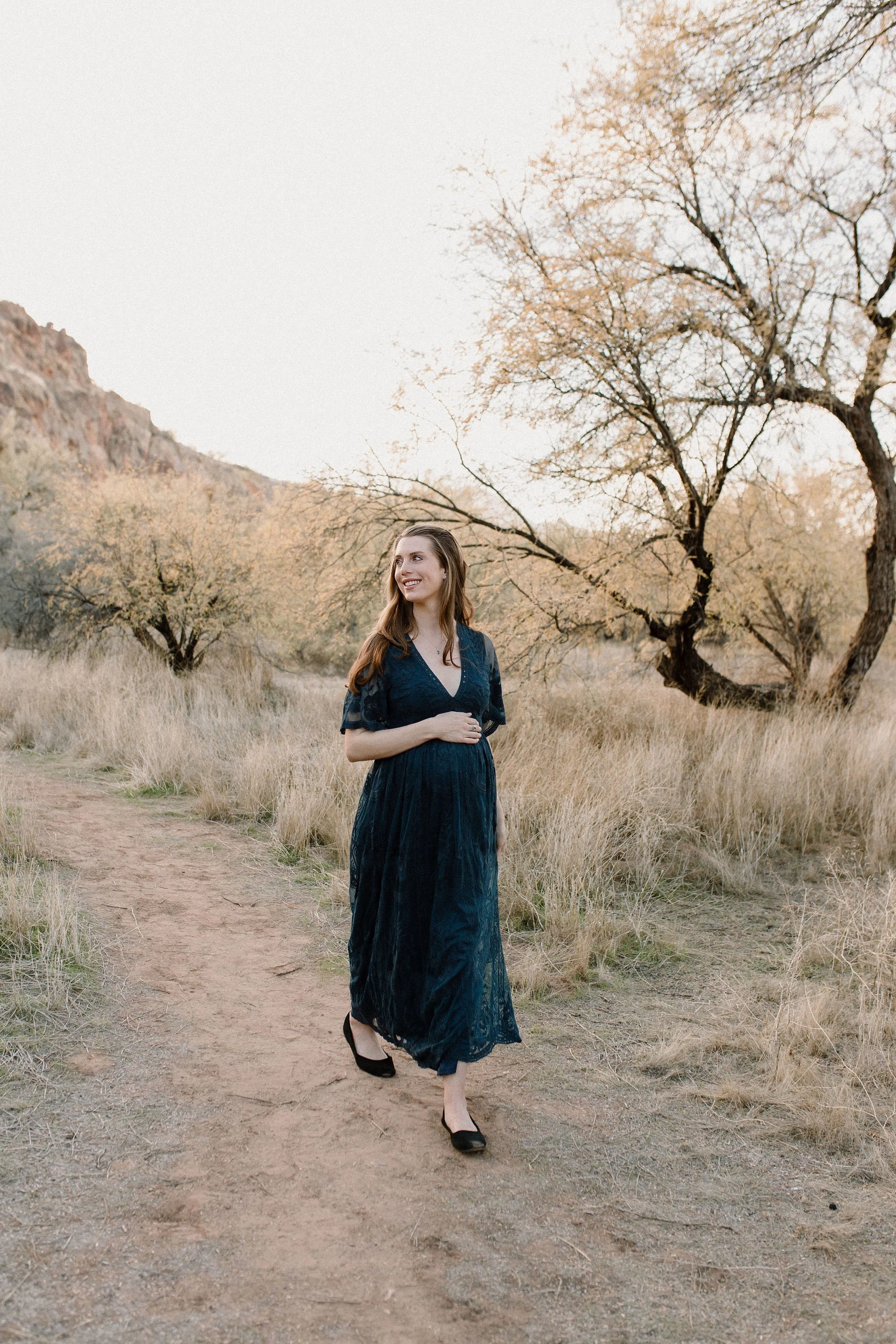 pregnant mom walking through desert during Salt River Mesa maternity photography session