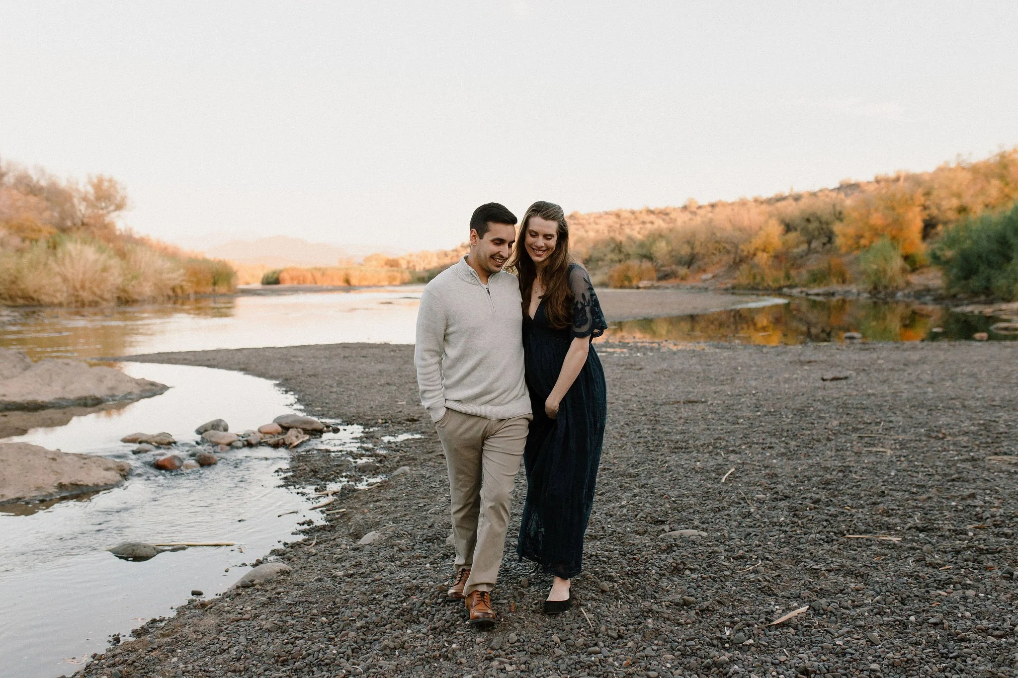 pregnant mom and husband walking by Salt River in Mesa maternity photography session