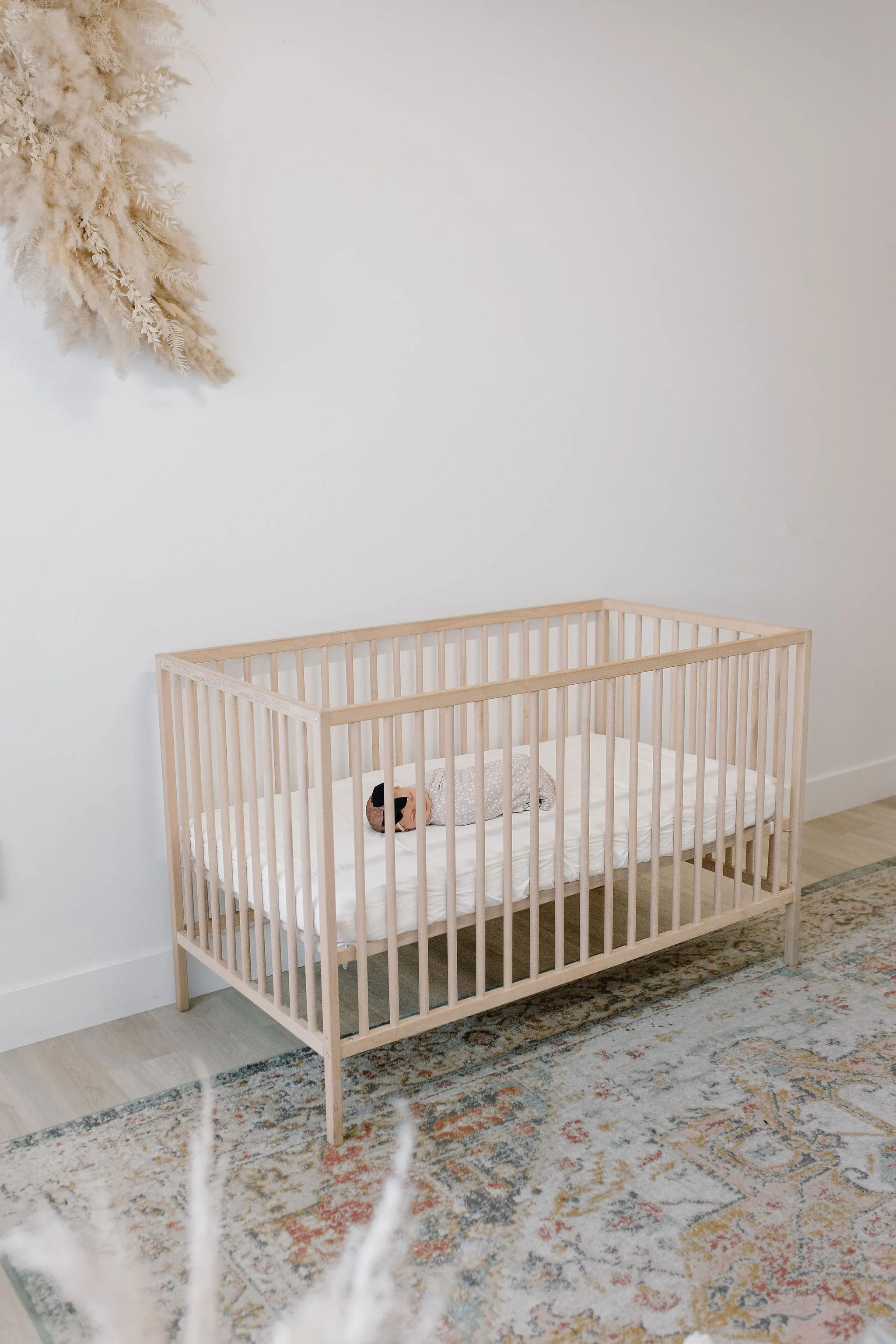swaddled newborn baby girl sleeping in neutral crib in studio in Mesa, Arizona