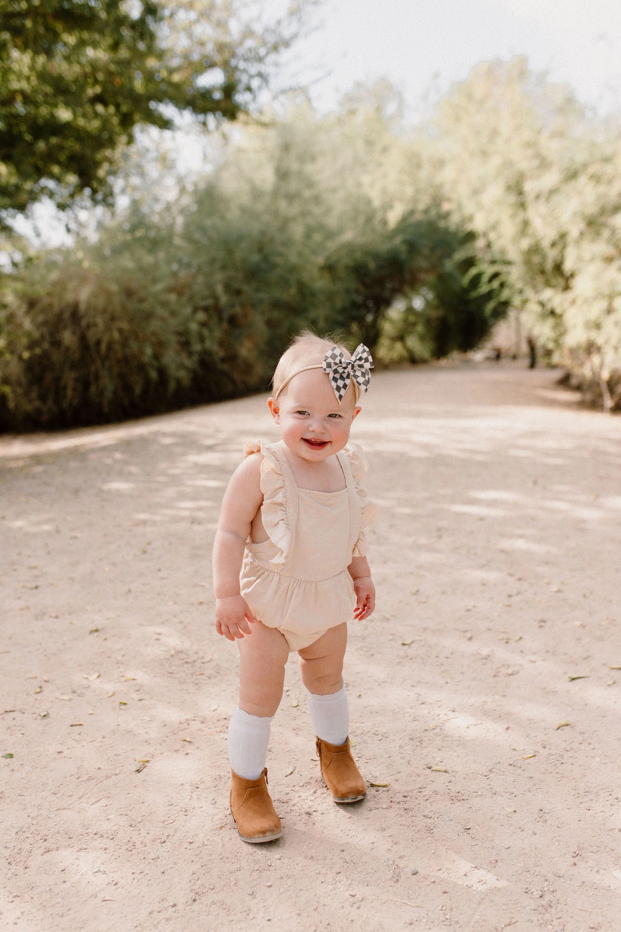 toddler standing and smiling in desert greenery family photography session