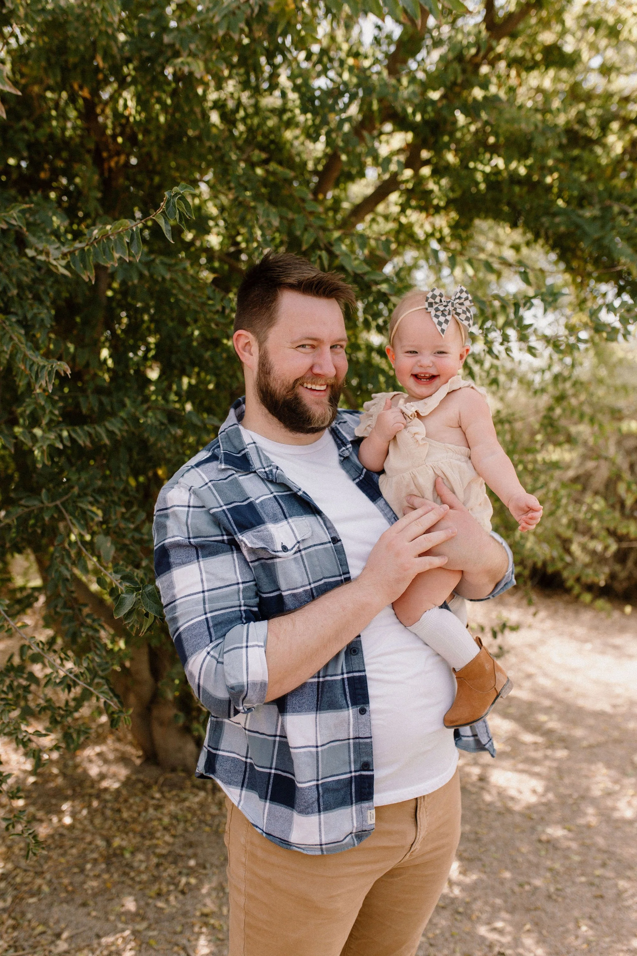 dad holding baby girl in desert greenery photography session