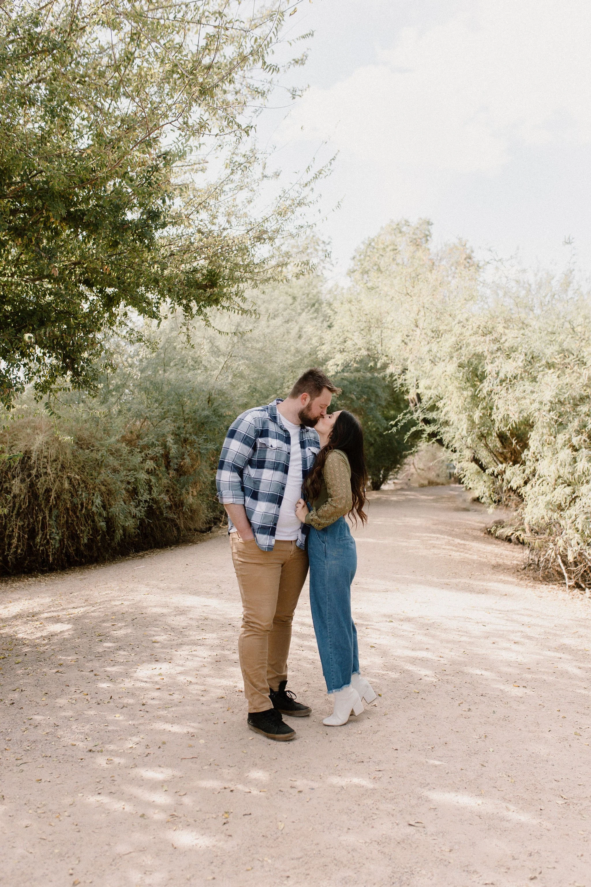 mom and dad kissing during desert greenery family photography session