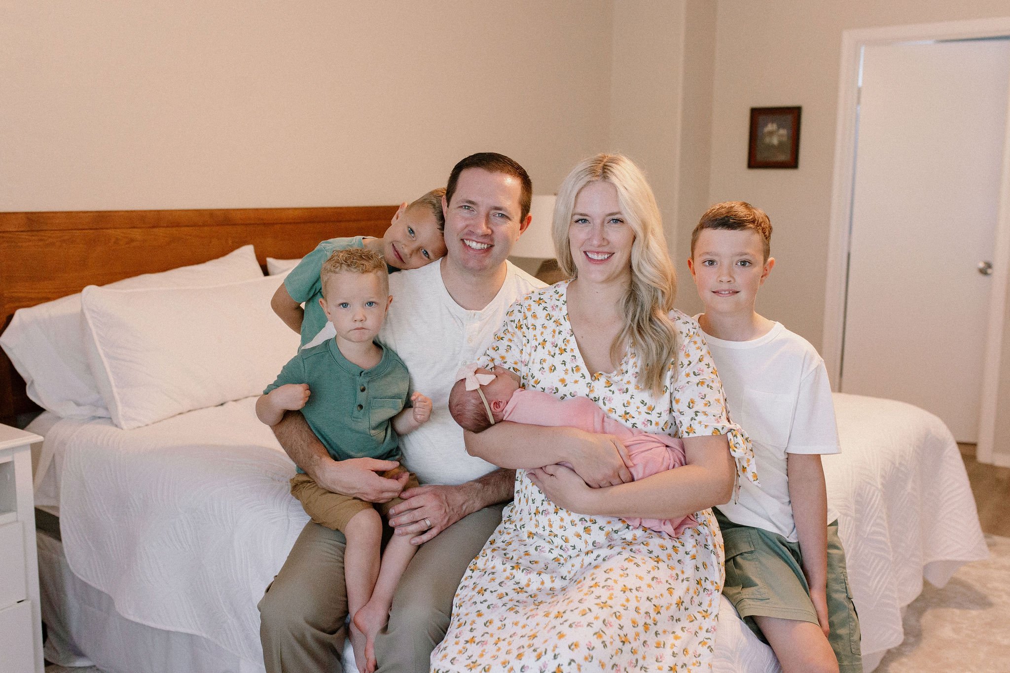 family sitting together smiling with newborn baby girl during lifestyle photography session
