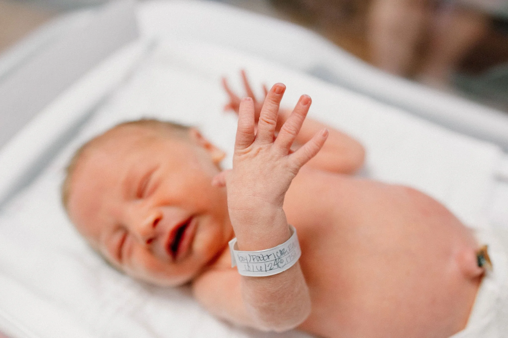 close up details photos of newborn baby boy's hands and fingers in hospital room after birth