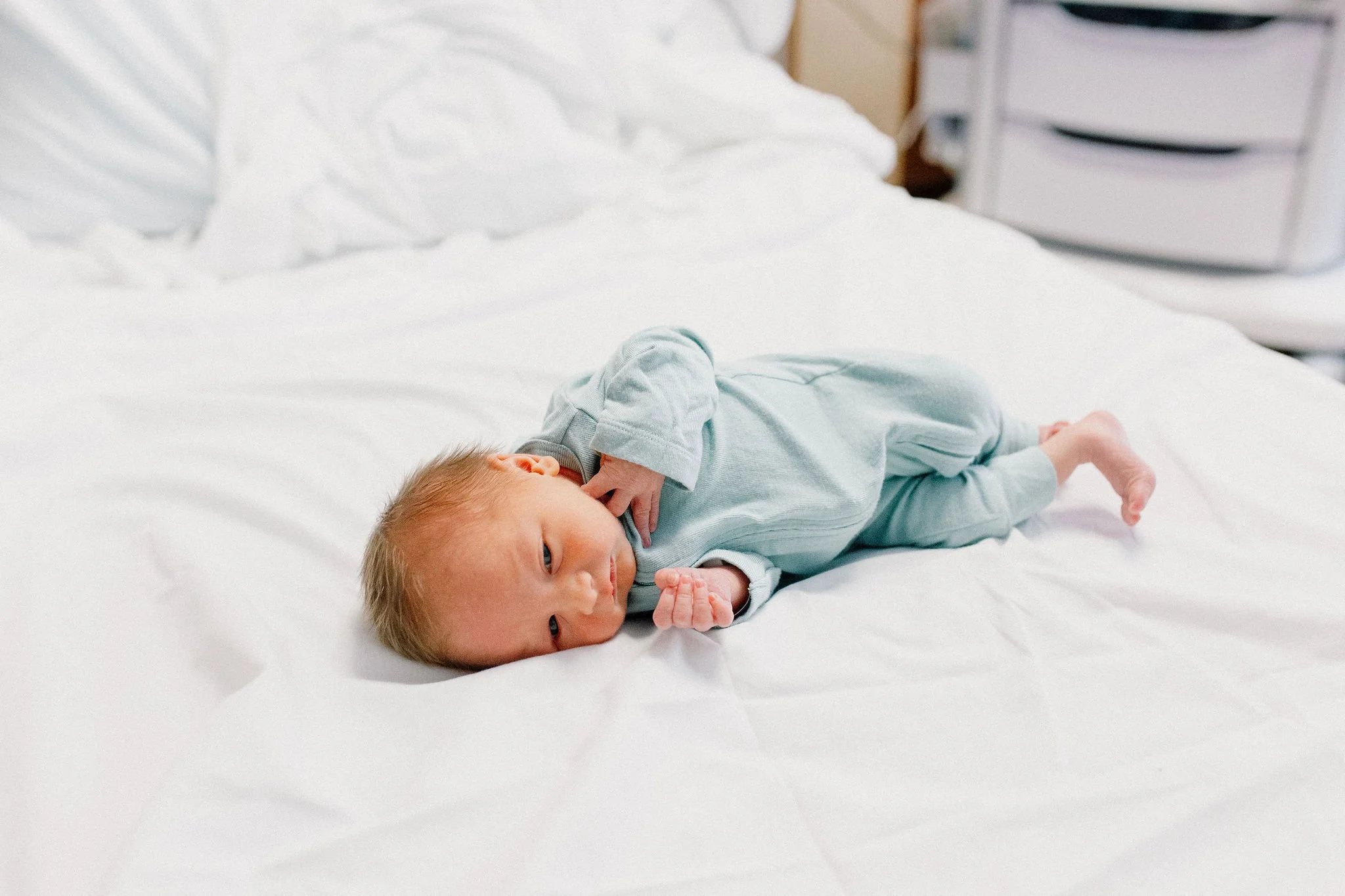 newborn baby boy laying on hospital bed after birth