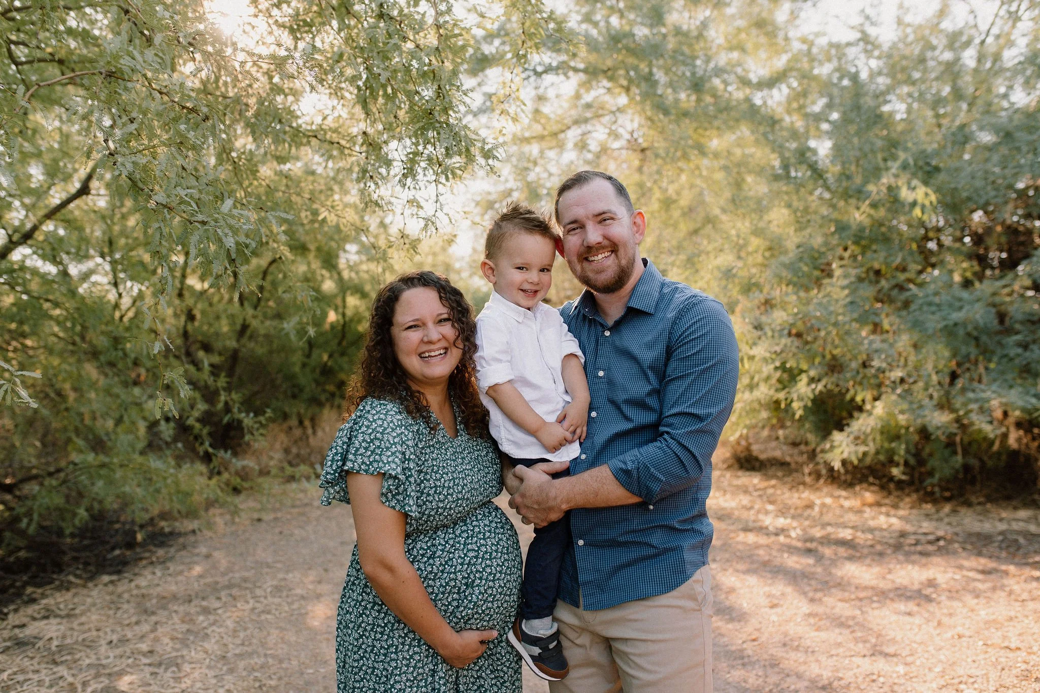 family of three standing and smiling during family maternity photography session