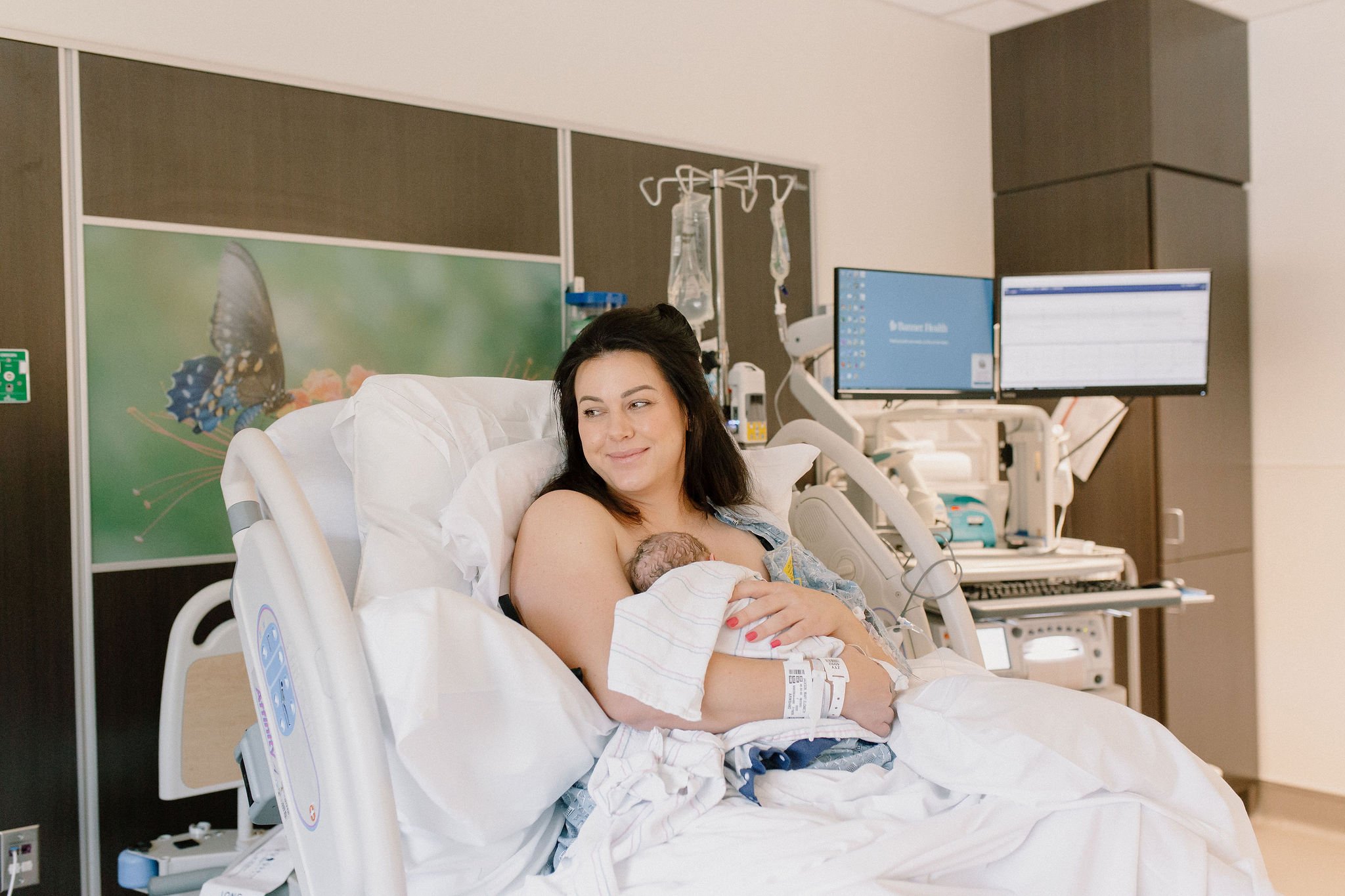 mom holding newborn baby hospital birth photography