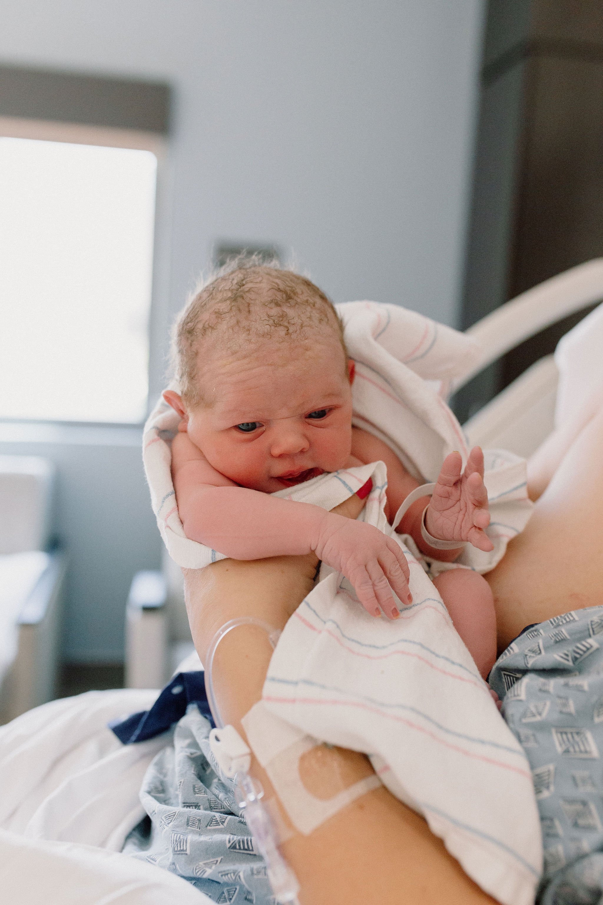 close up of newborn baby after birth in hospital bed