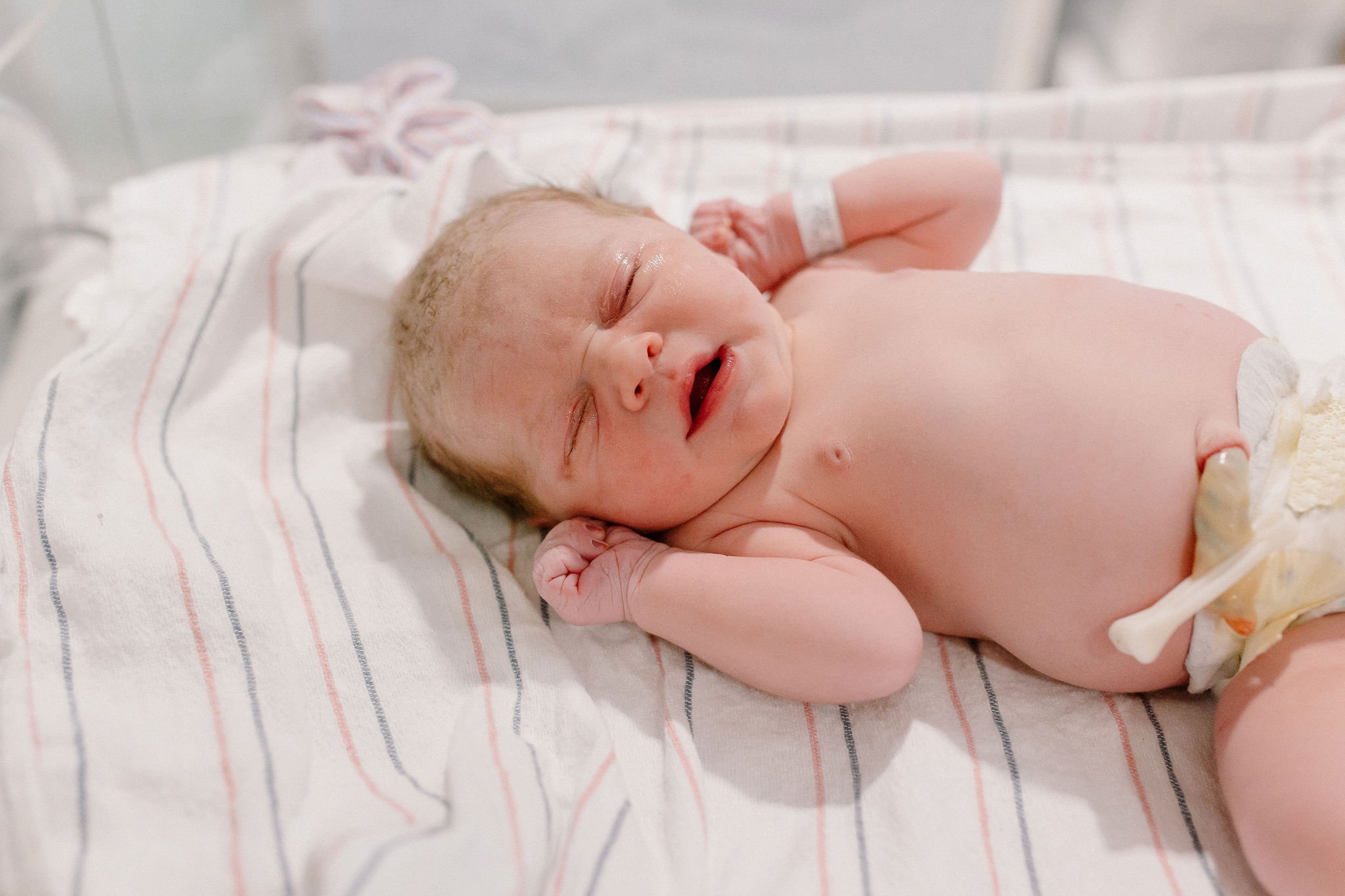 newborn baby girl in bassinet at hospital after birth