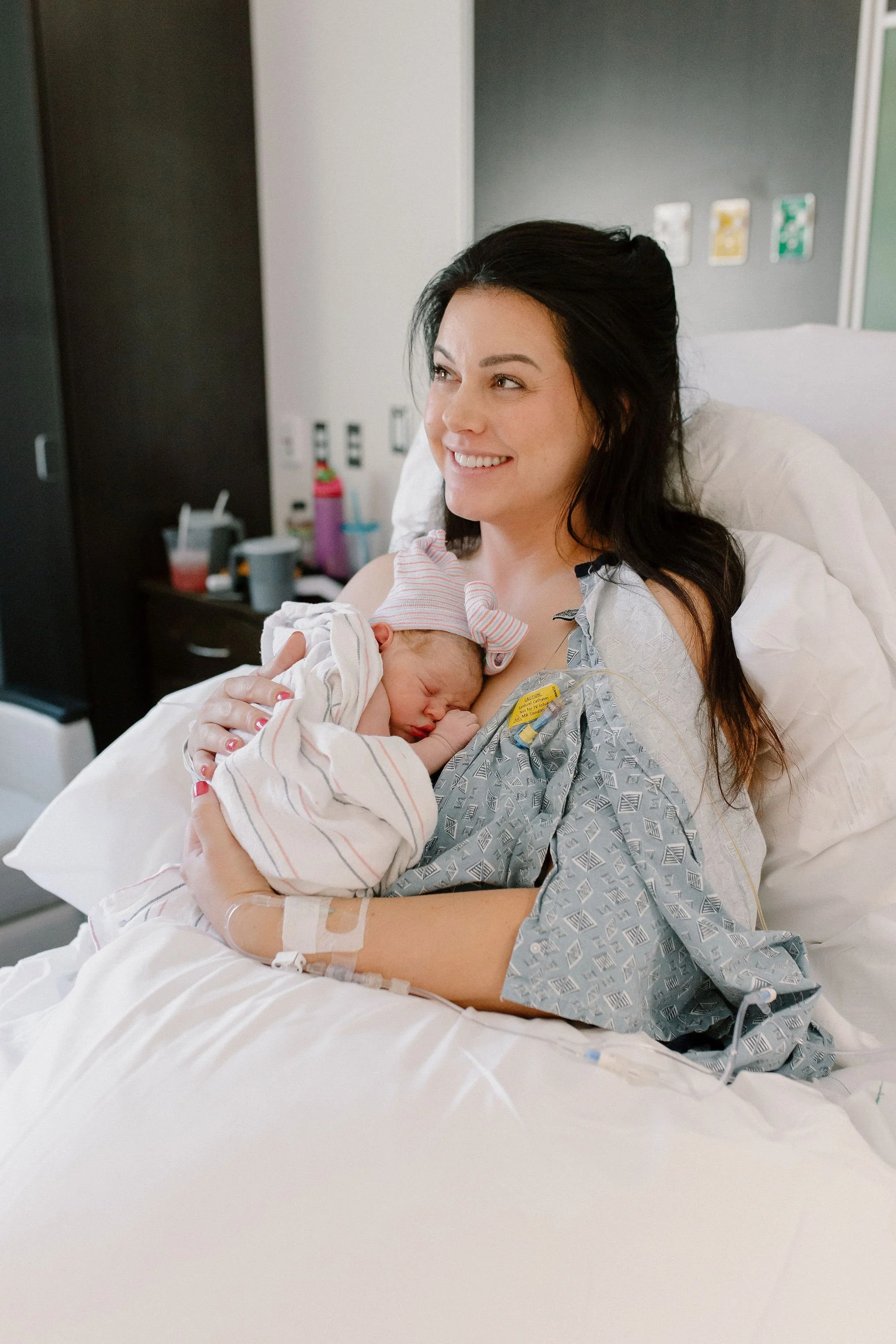 mom holding newborn baby after hospital birth photography in Gilbert Arizona