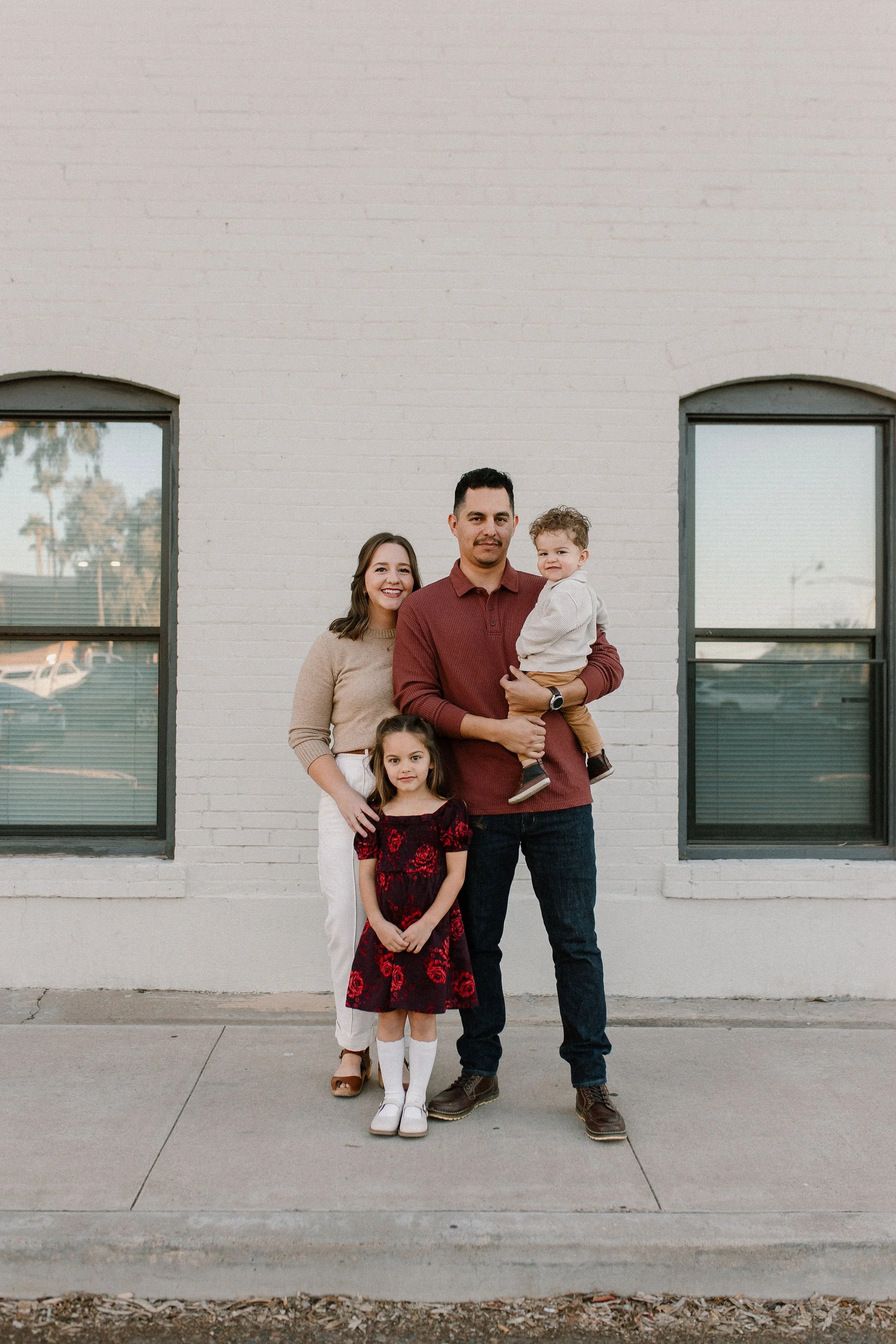 Family of four standing together and smiling in downtown Mesa family photography session