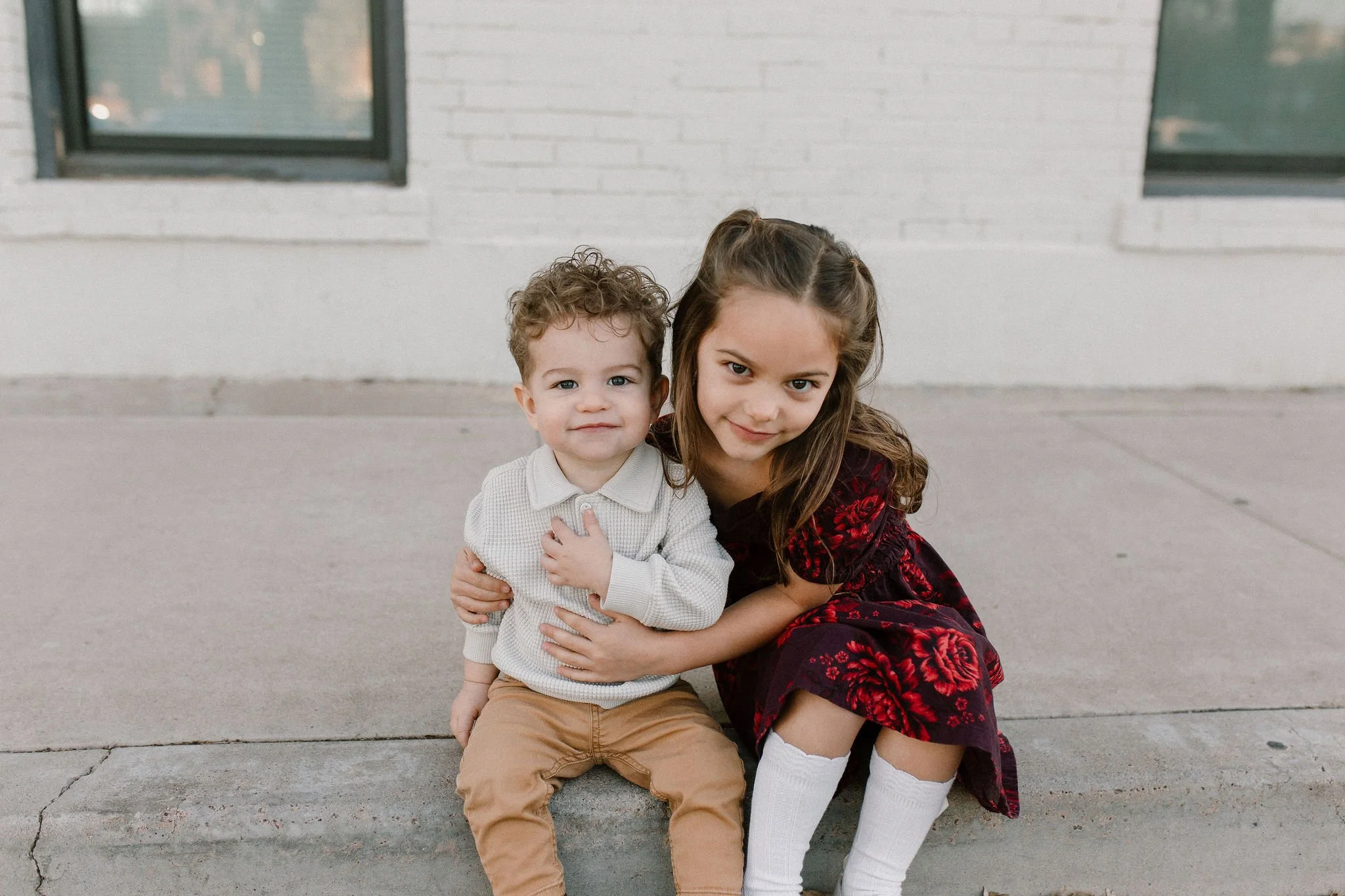 siblings sitting together and smiling in downtown mesa family photography session