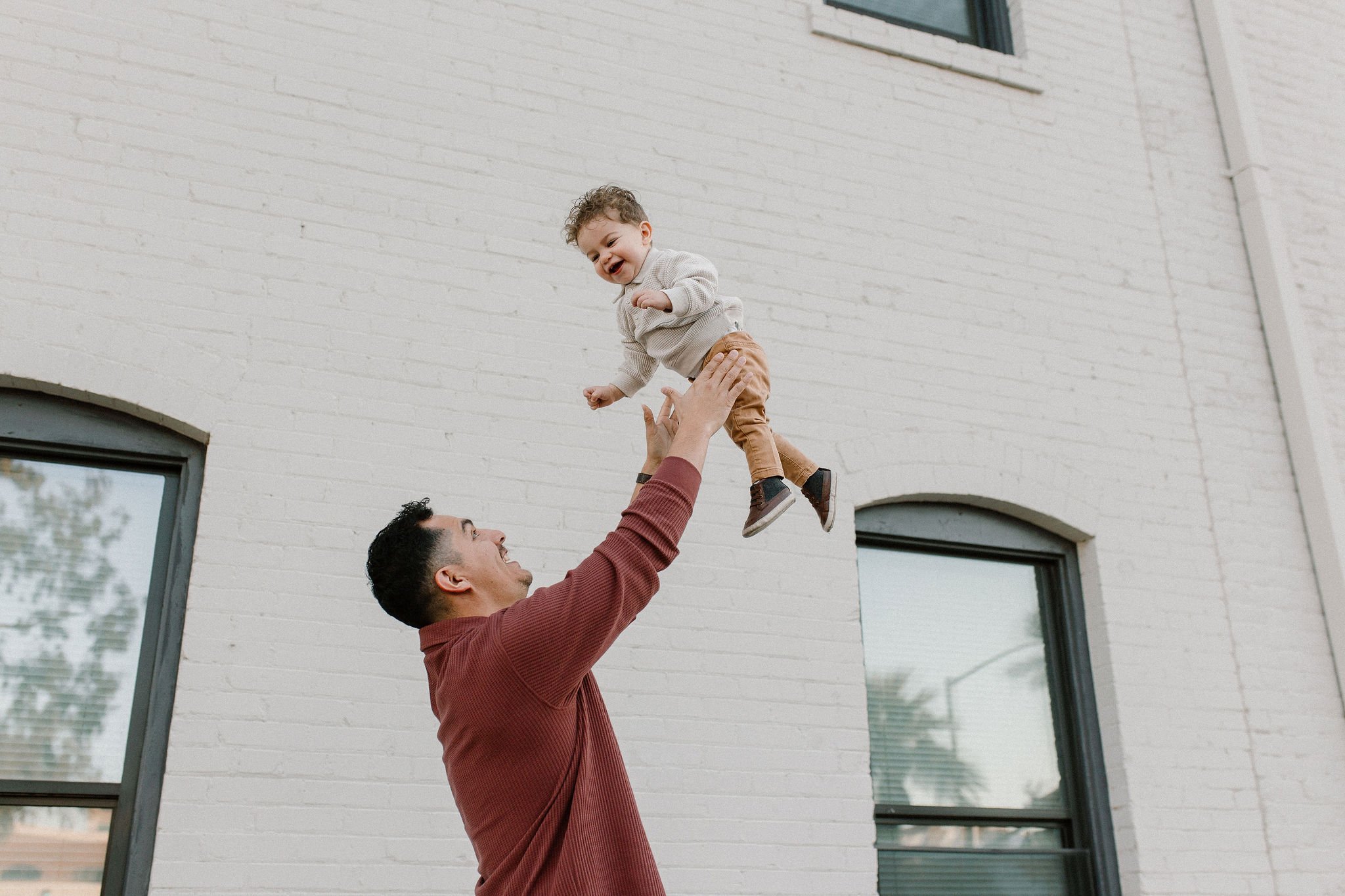 dad throwing son in the air during downtown mesa family photos