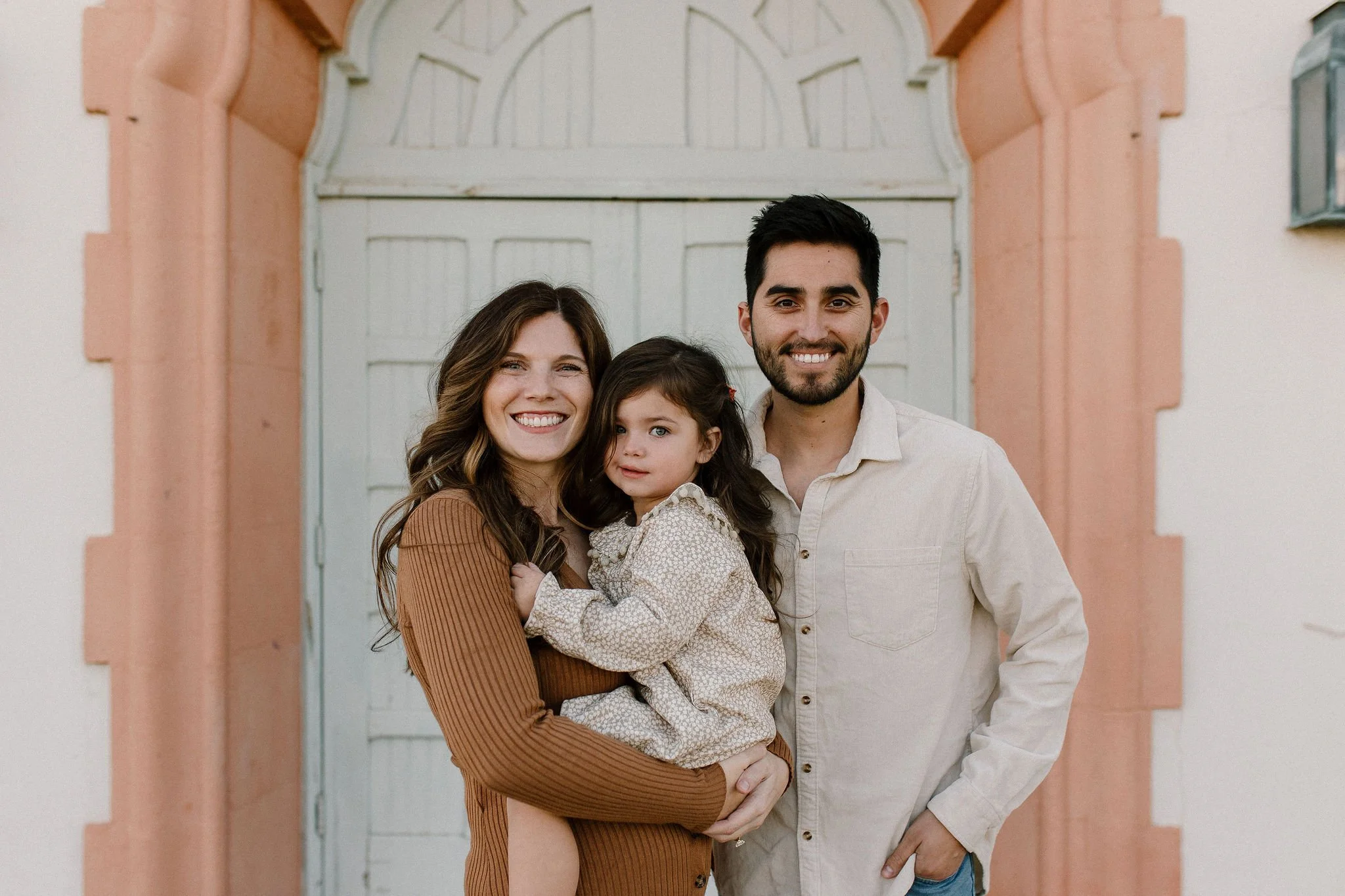 pregnant mom with dad and toddler smiling during family photo session