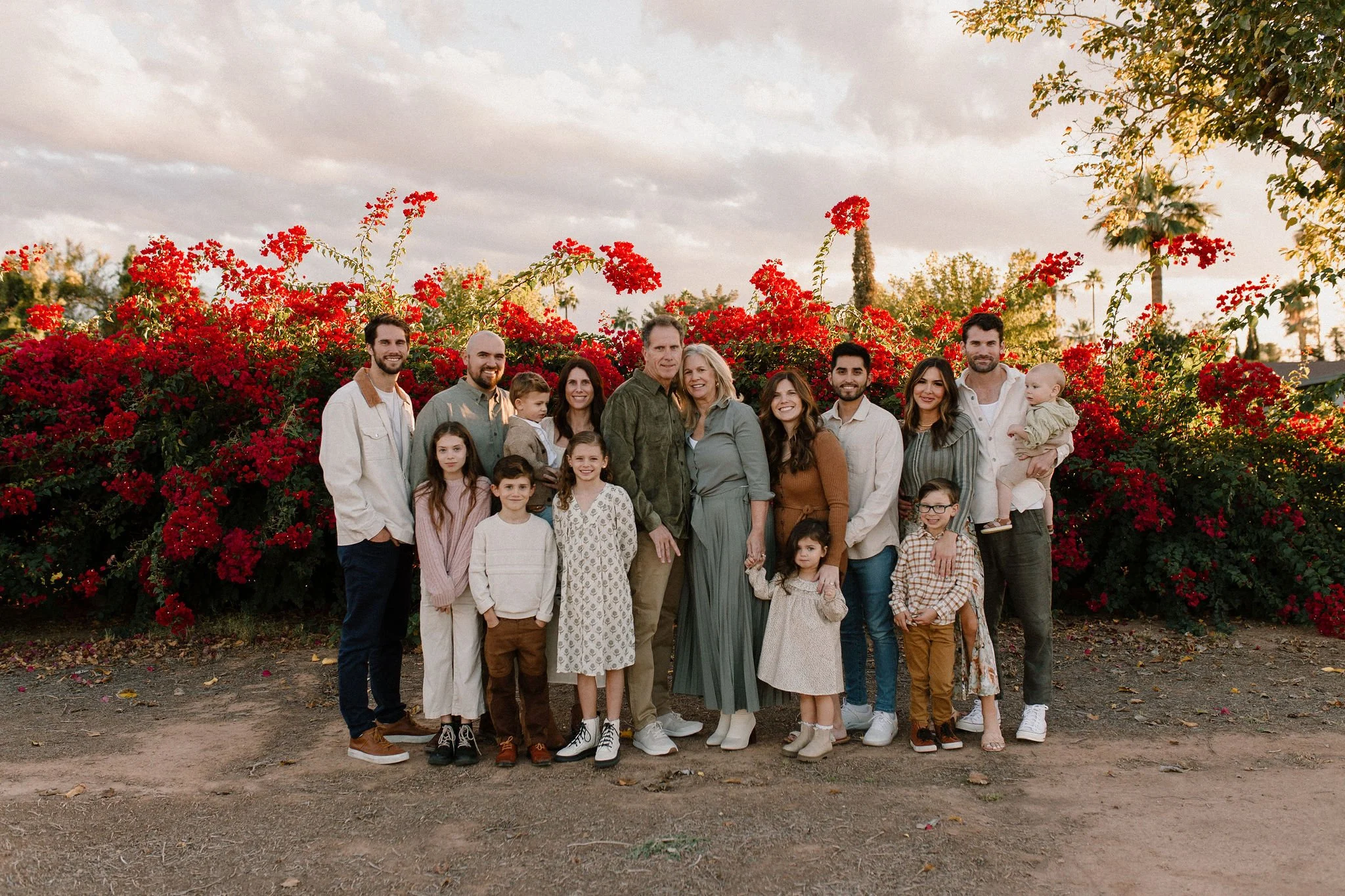 large family smiling in front of bougainvilleas during extended family photos