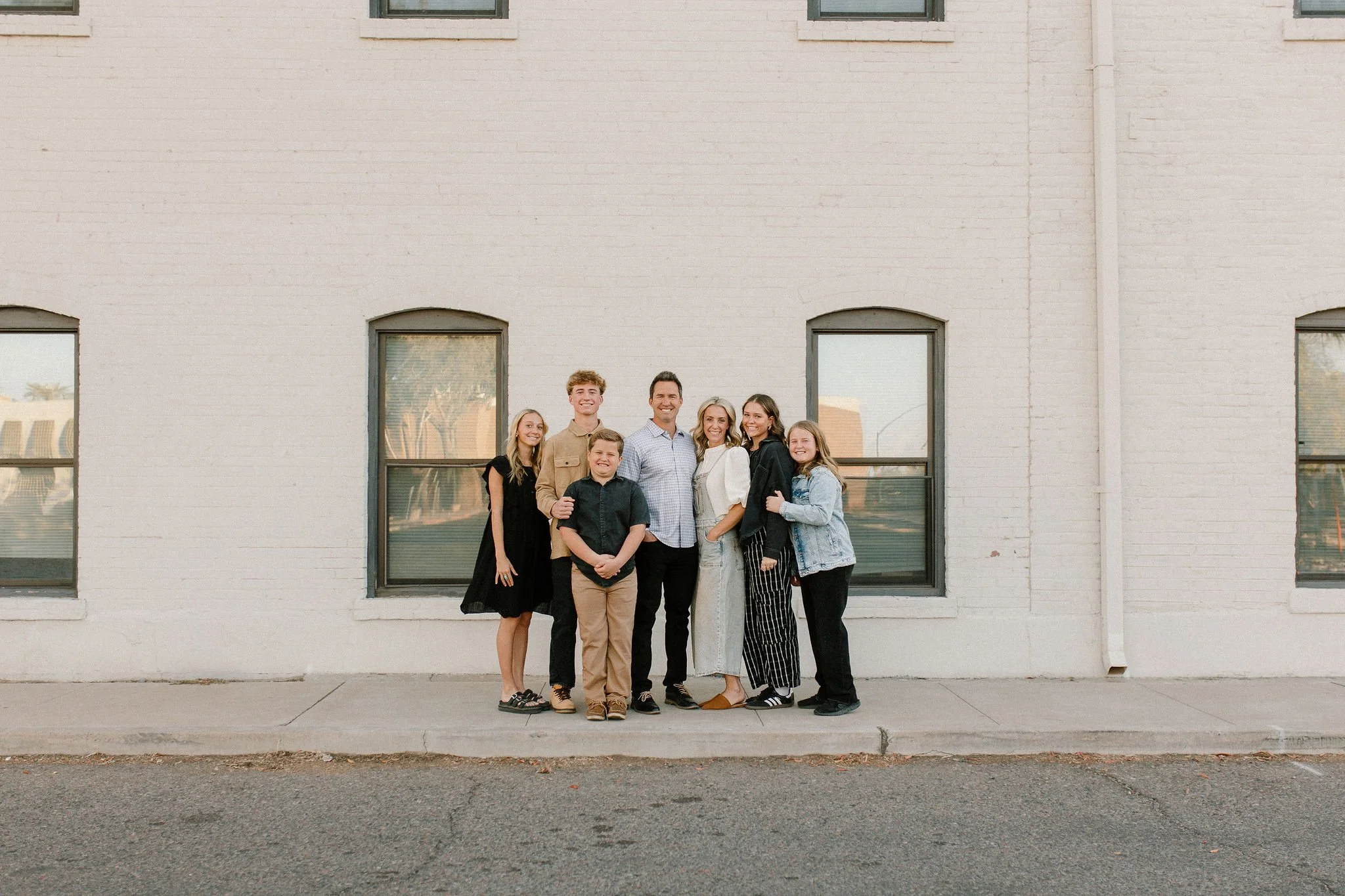 Family standing close in front of urban white wall in Downtown Mesa family mini sessions photos