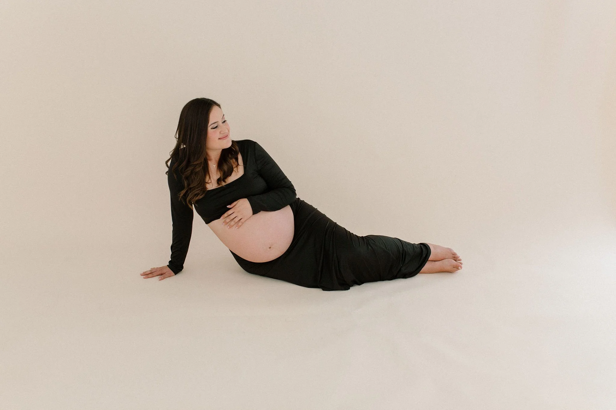 pregnant mom sitting in a clean aesthetic studio Gilbert maternity photography
