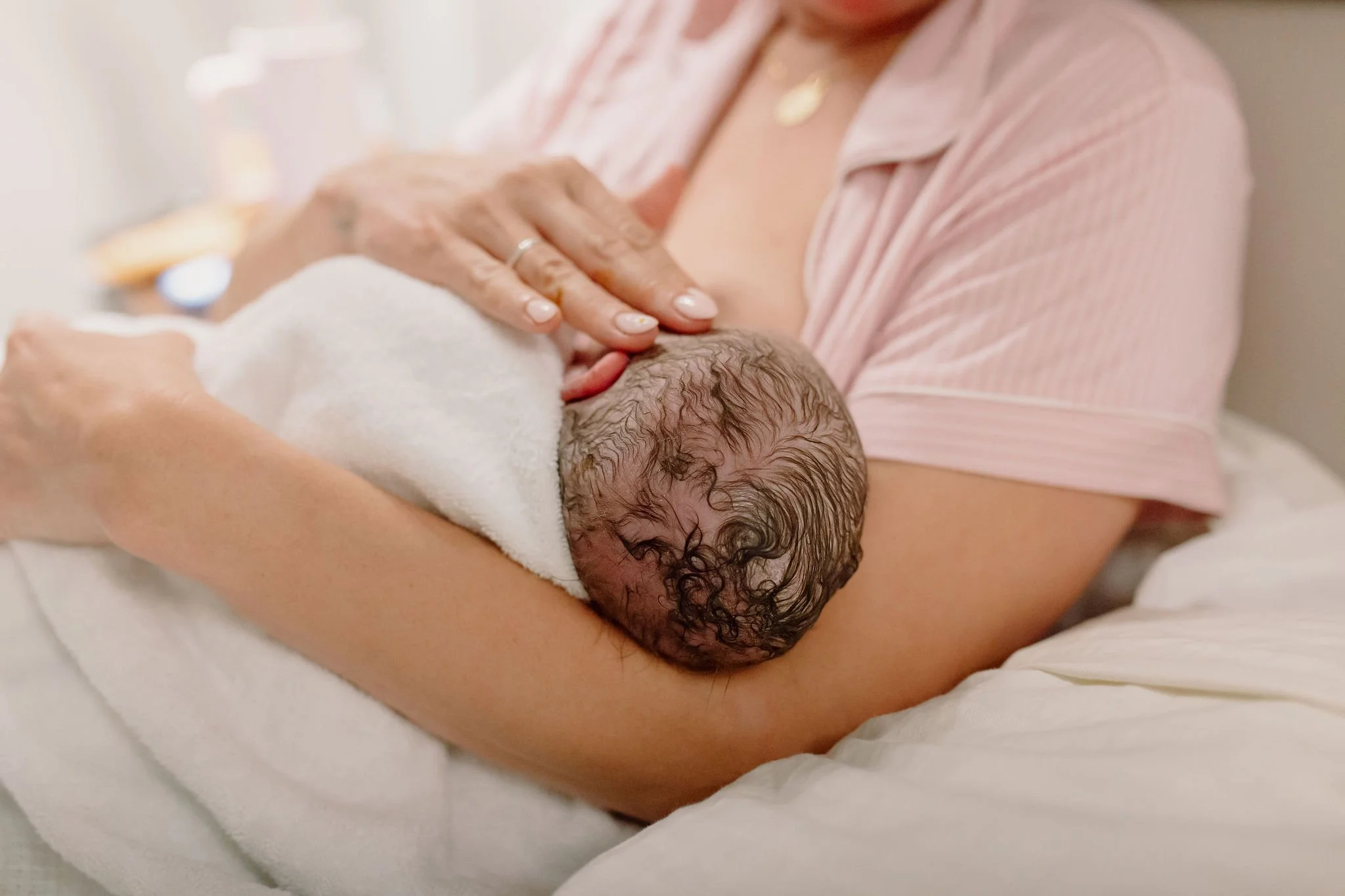 mom holding newborn baby details shot in hospital birth photography session