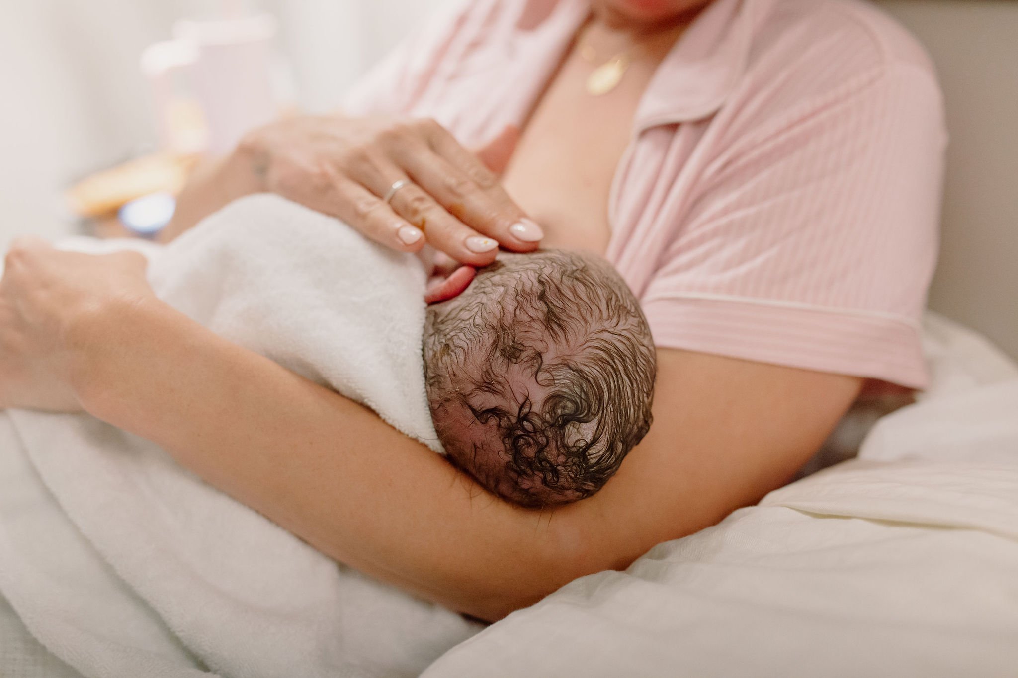 mom holding newborn baby details shot in hospital birth photography session