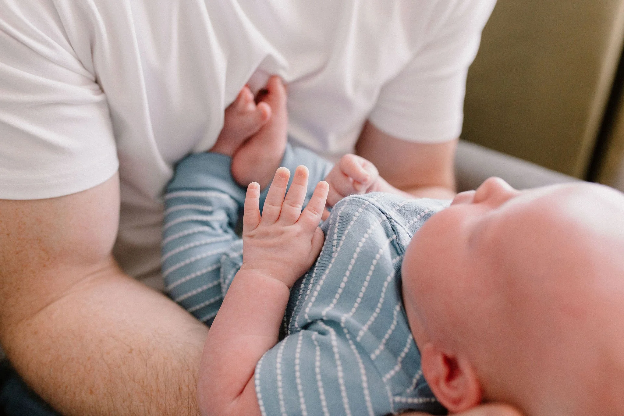 dad holding newborn baby details of baby's toes and fingers in lifestyle photography session in Gilbert, Arizona