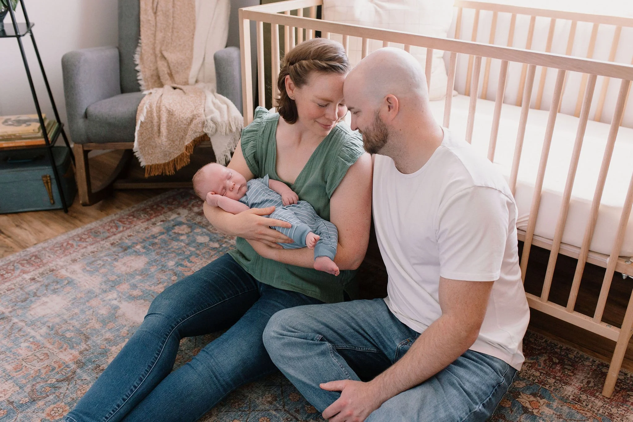 mom and dad holding baby in nursery in-home newborn photoshoot in Gilbert, AZ
