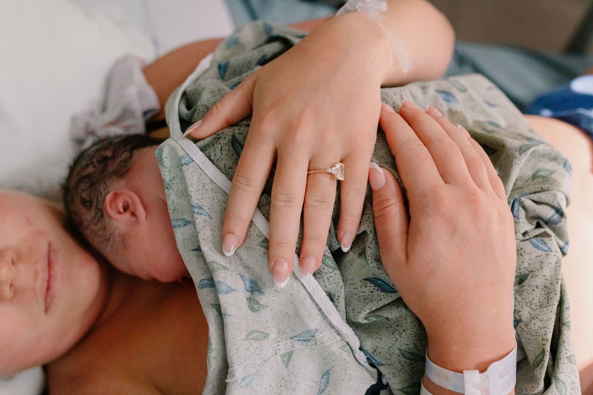 mom holding newborn baby hospital birth photography