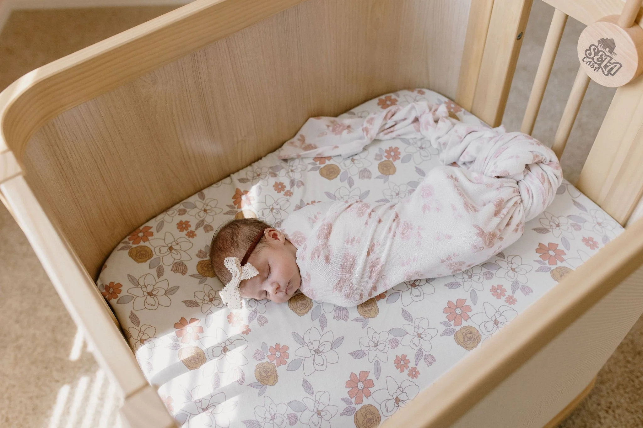 newborn baby swaddled in blanket sleeping in crib