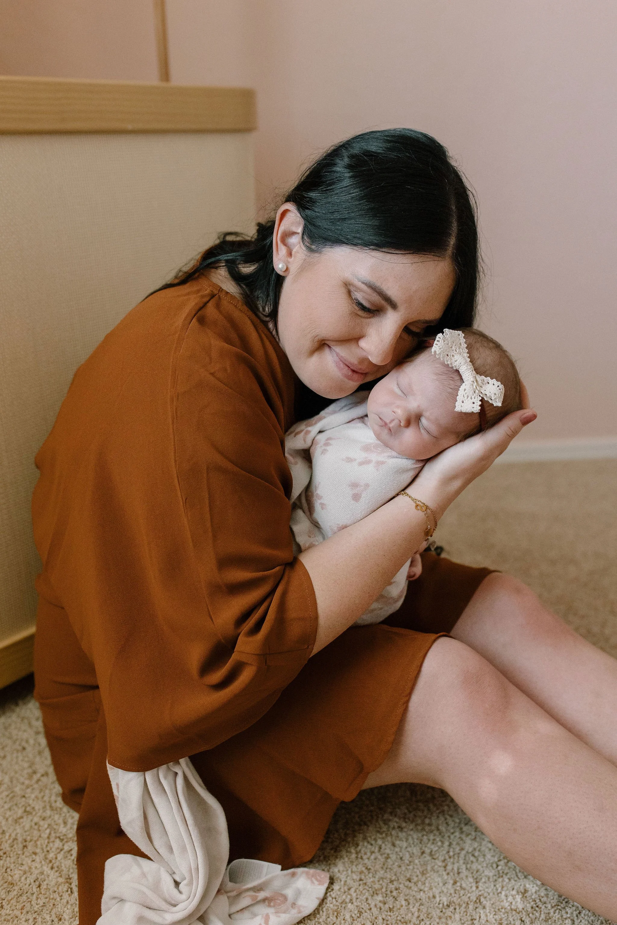 newborn photographer captures mom cuddling baby in nursery lifestyle session