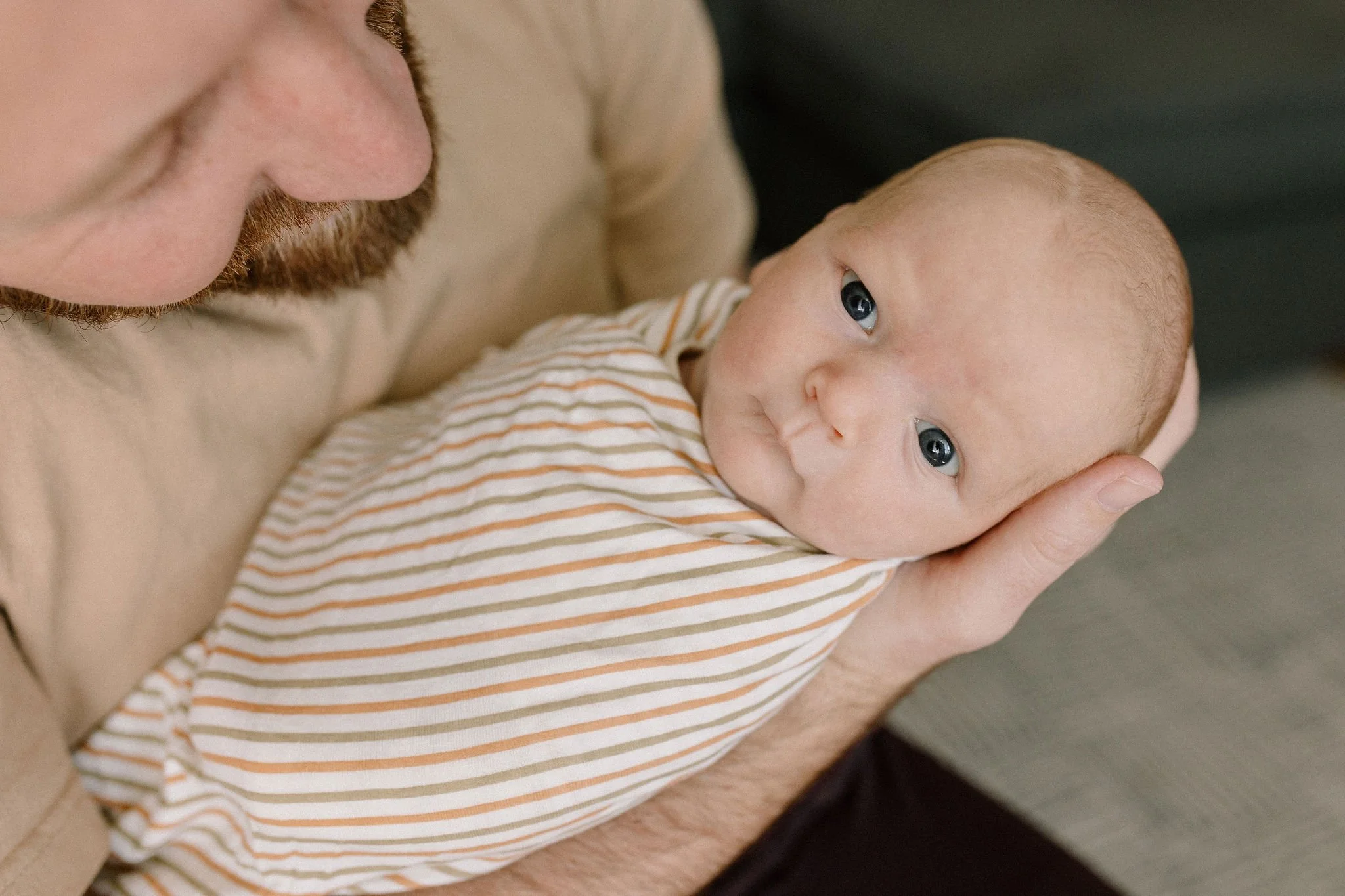 dad holding newborn baby boy in home lifestyle photoshoot in Gilbert Arizona