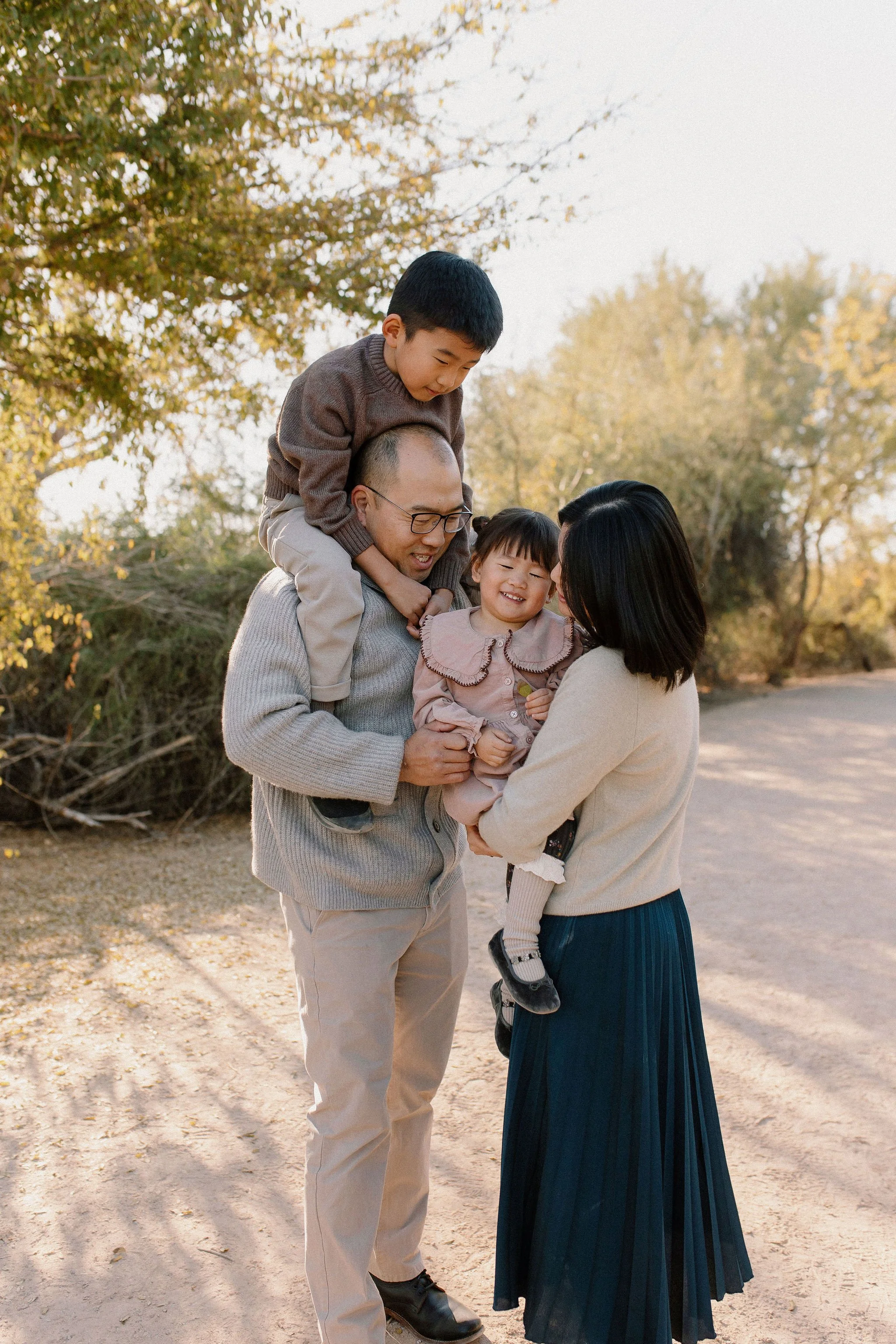 family photographer captures cuddling moment with parents and toddler in Arizona at Gilbert Riparian Preserve