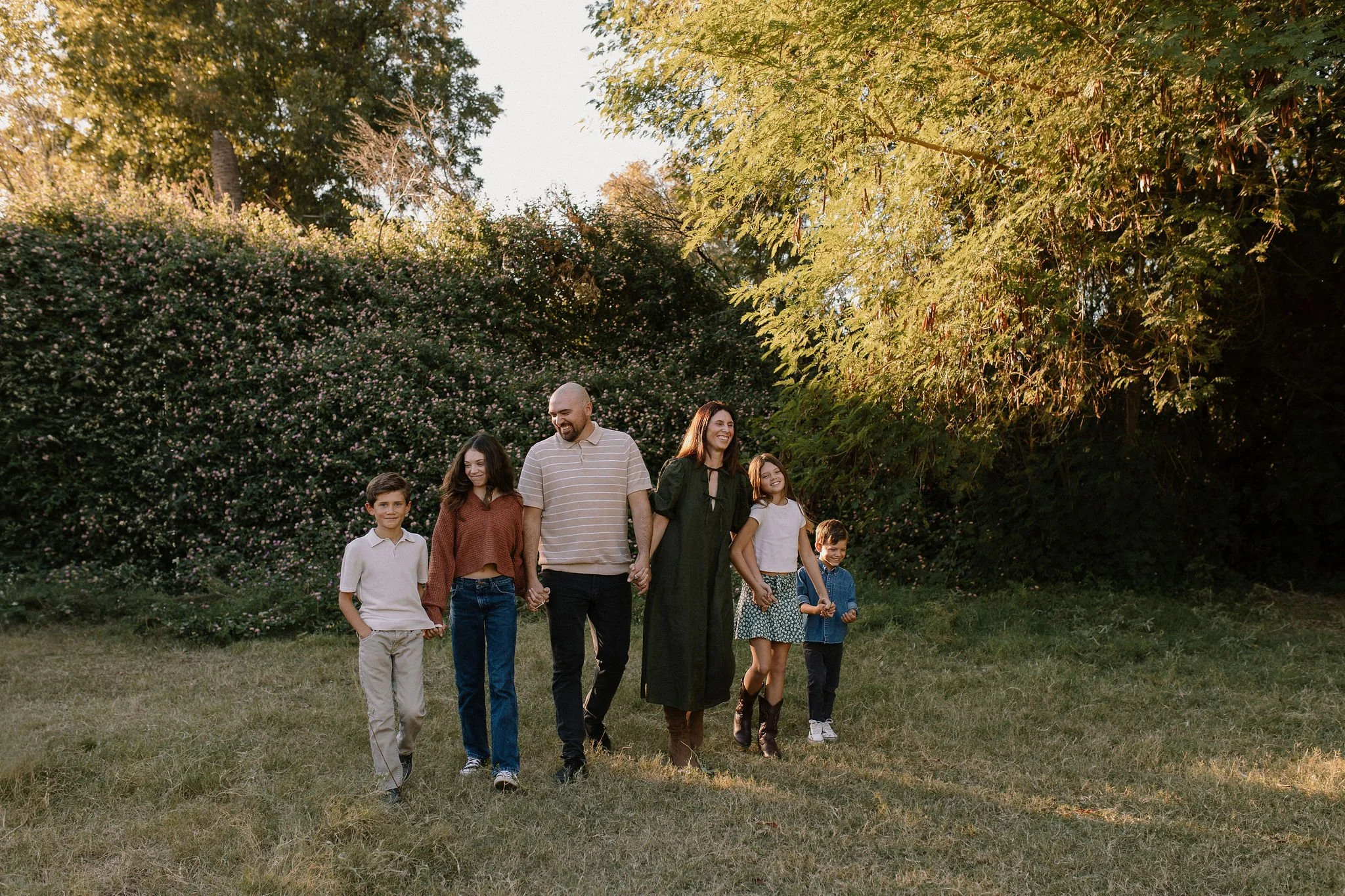 family walking together holding hands during golden hour photography session in Gilbert AZ