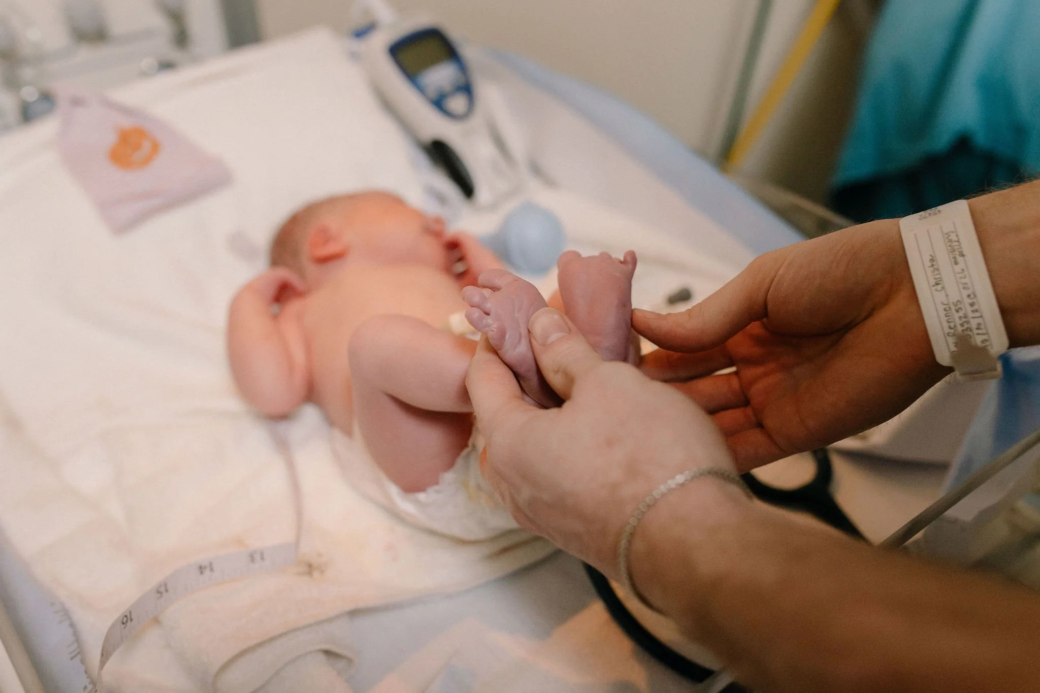 newborn baby details close up of dad holding feet and toes in warmer in hospital photoshoot in Gilbert, Arizona