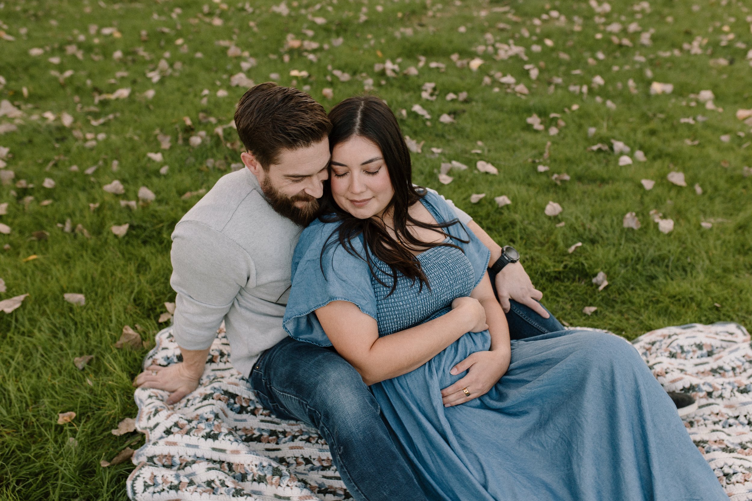 mom and dad cuddling maternity photoshoot Gilbert greenery Arizona holding pregnant belly