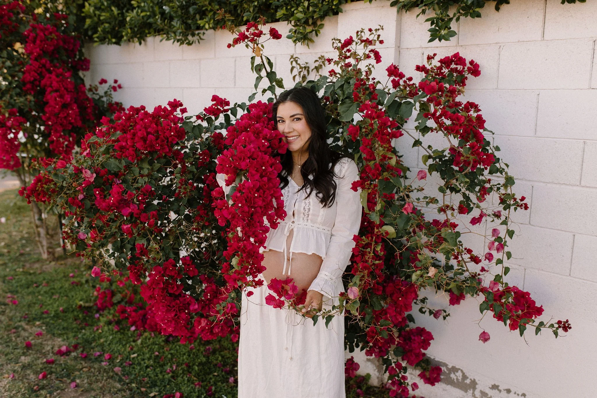 pregnant mom standing in bougainvillea flowers taken by Mesa maternity photographer