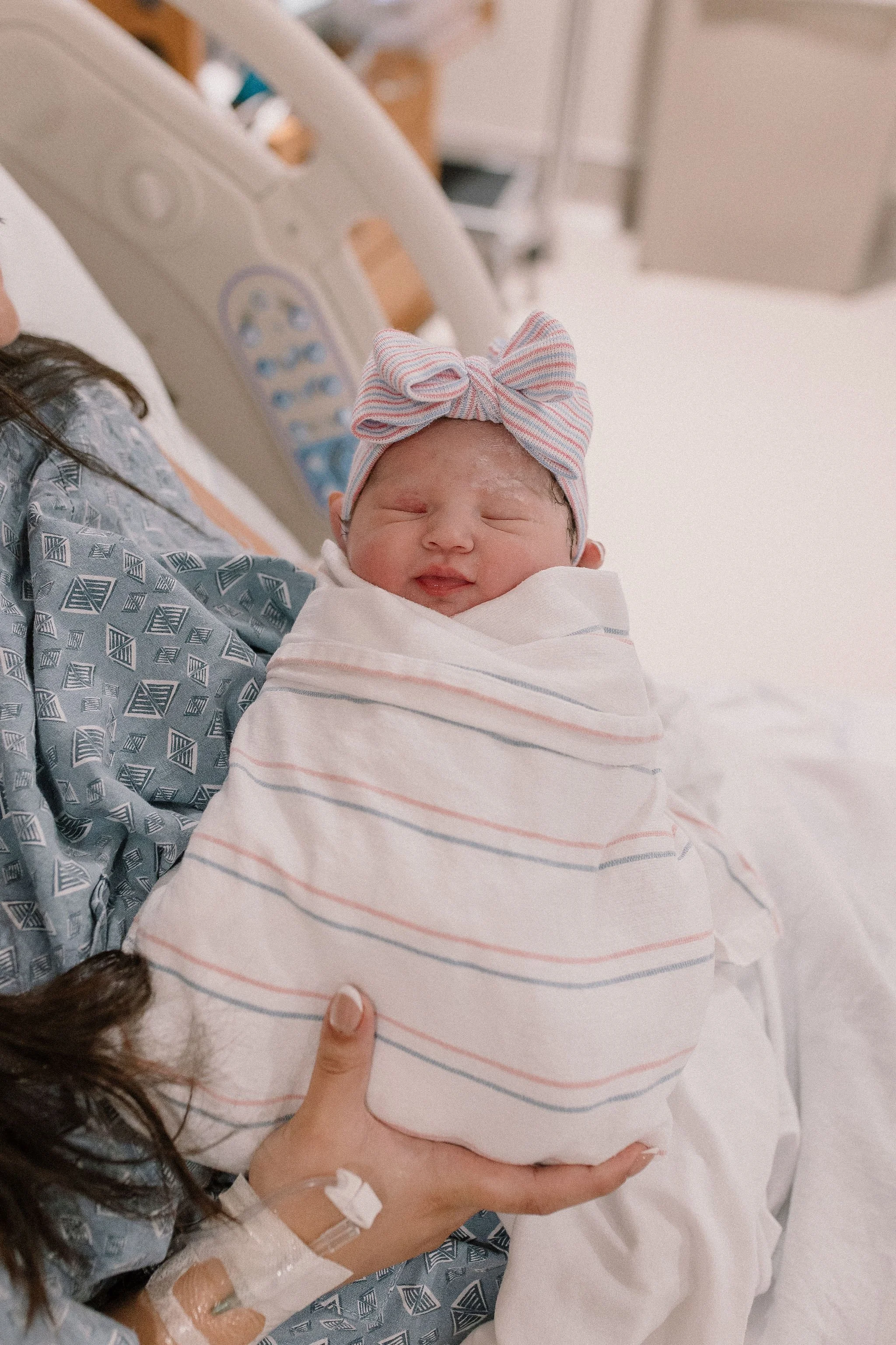 swaddled newborn baby girl in hospital birth photography session