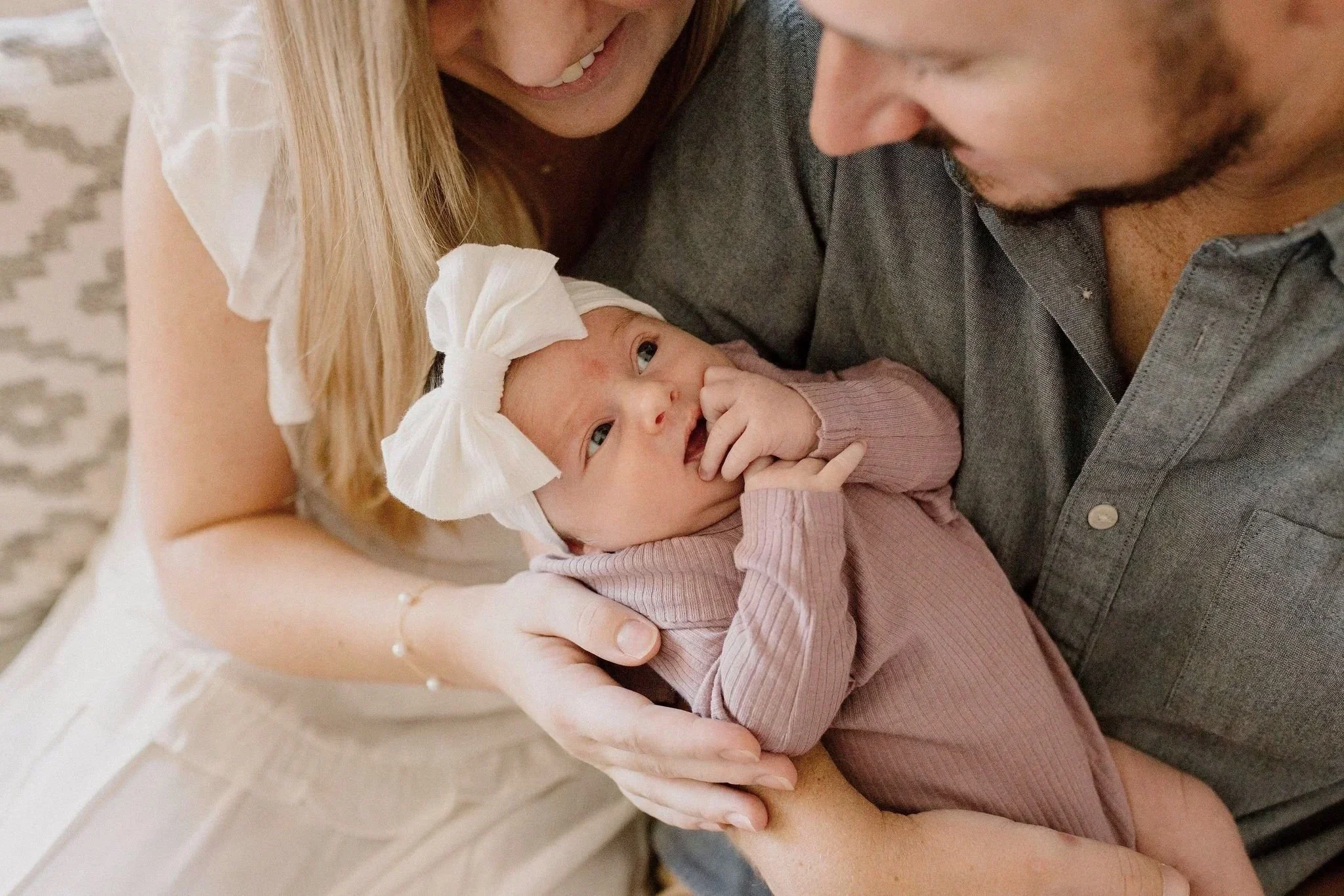beautiful moment captured by Mesa newborn photographer of mom and dad holding and smiling at baby girl