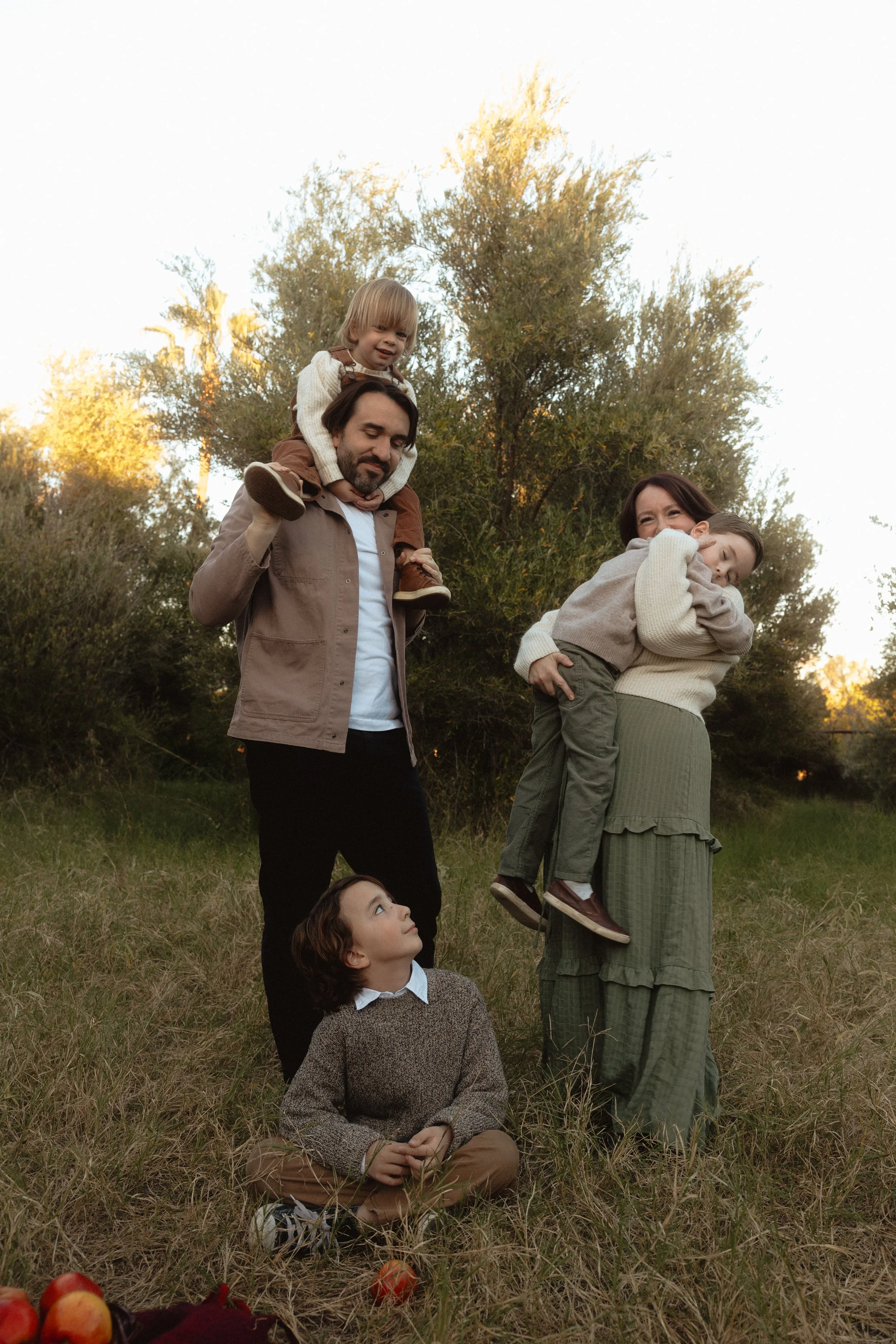 family standing together in an apple orchard