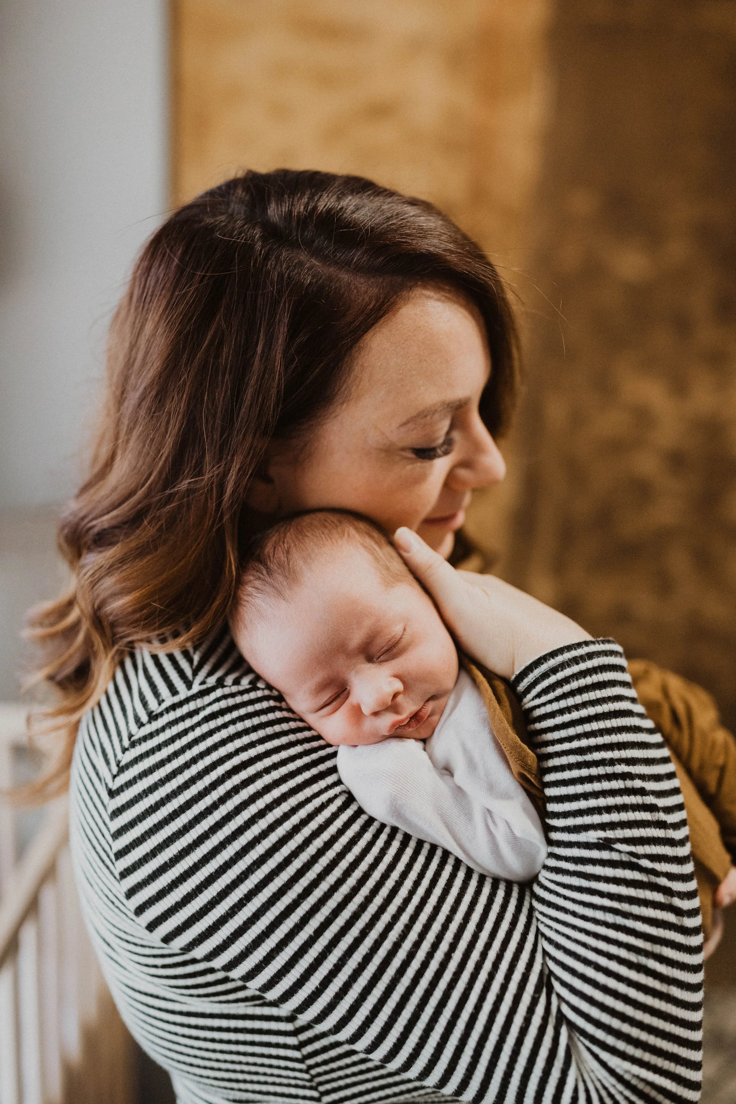 newborn photographer holding newborn baby in Arizona nursery lifestyle session