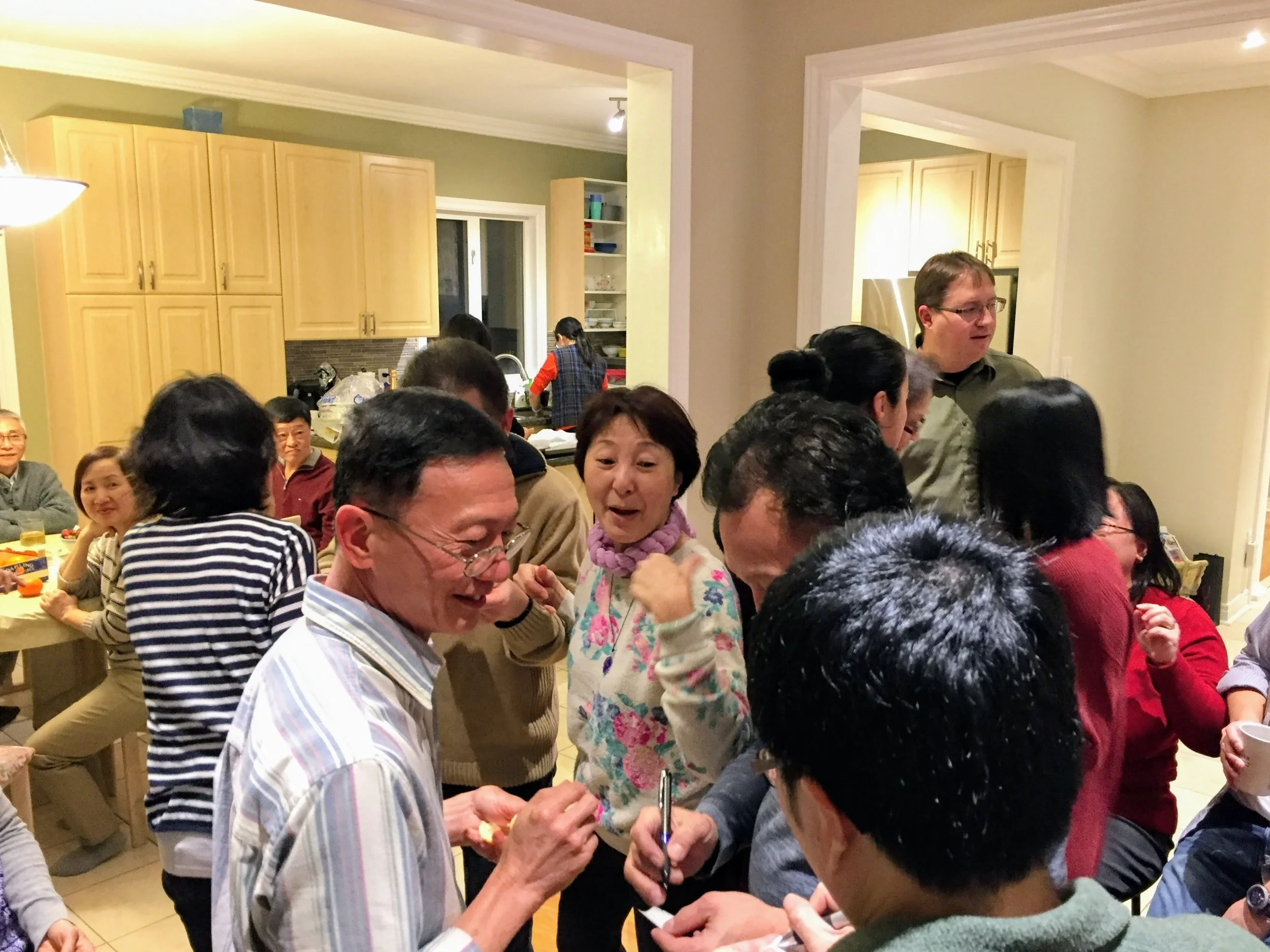 a family gathering, a chaotic scene of people clustered together, laughing, talking, sharing.