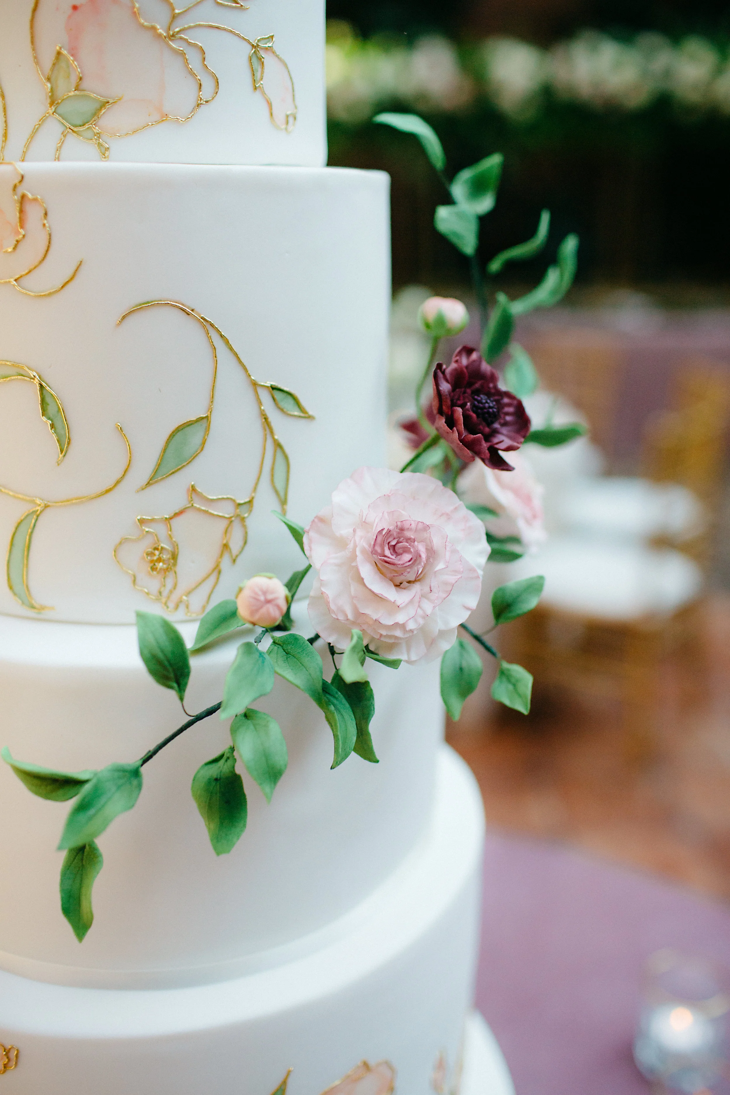 Hand-painted flower cake with gold detail and hand-made sugar flowers. Photo by Amanda Dumouchelle.