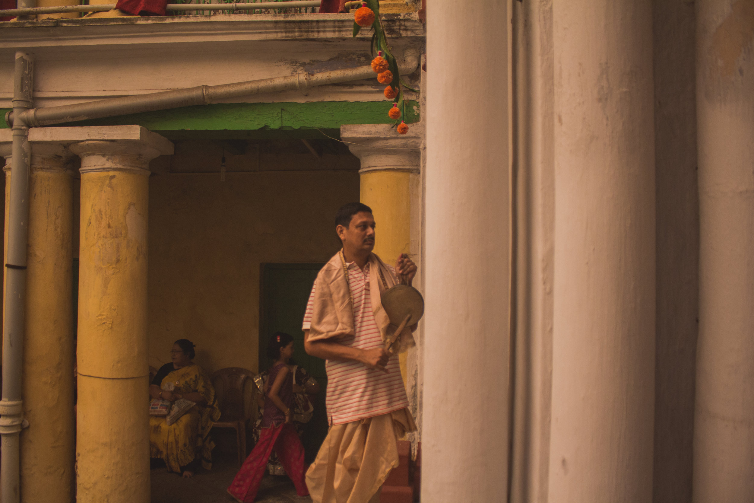  Music is a big part of such ceremonies. Here, a member of the house is seen playing the  kashor , a metal cymbal-like instrument suspended by a rope. The player usually beats the instrument to the rhythm of the  dhak .&nbsp; 