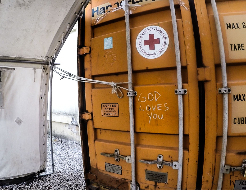 A chalk inscription on a medical storage container in Diavata camp. Christian charities were working in the camp, attempting to put a stopper on the rising numbers of sexual trafficking of refugees.