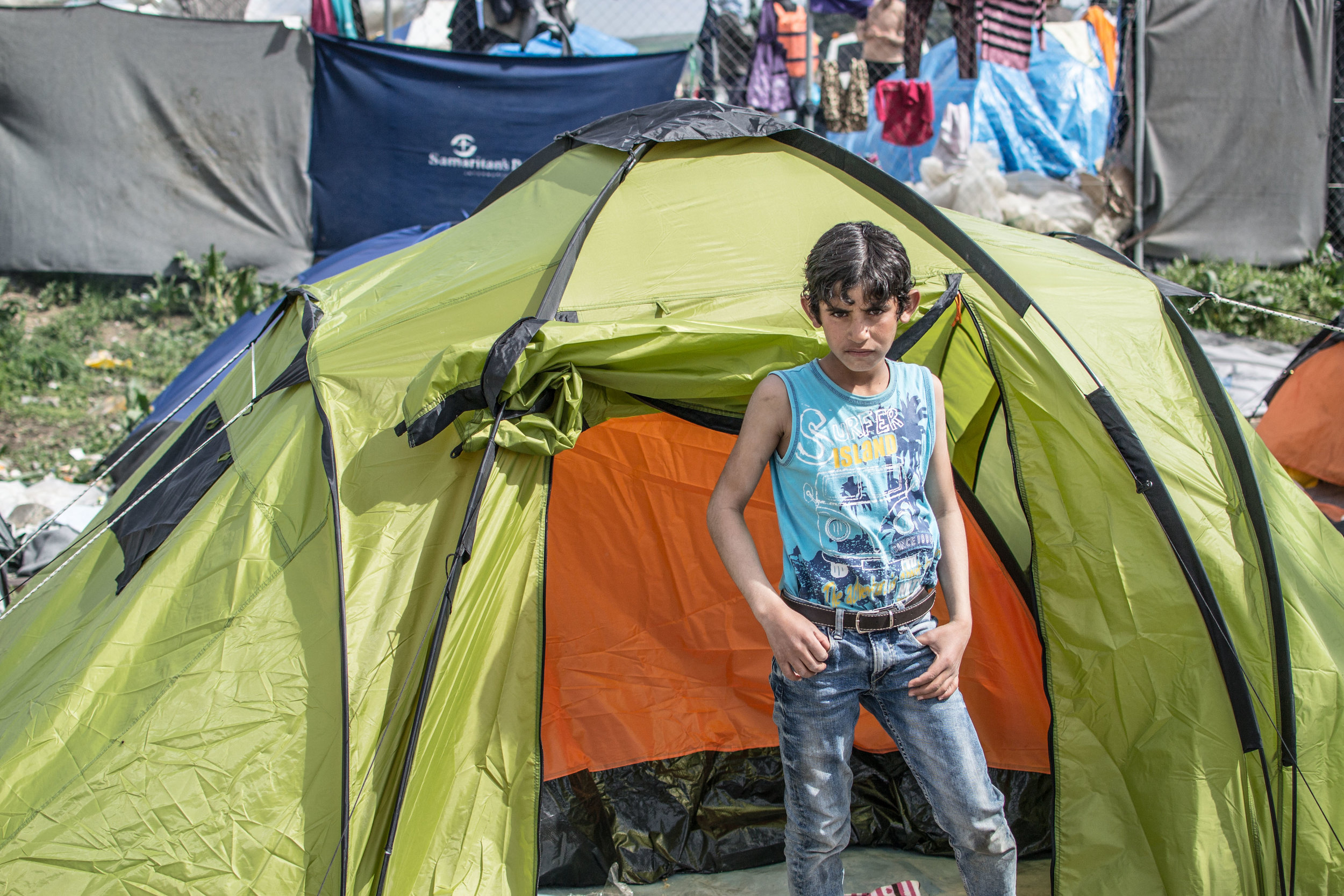 A defiant young boy frowns at the camera as I walk intrusively through his camp area. It was difficult to determine where I could walk, as families gathered together in personal spaces away from the western aid tents. However, I was invited in by ma
