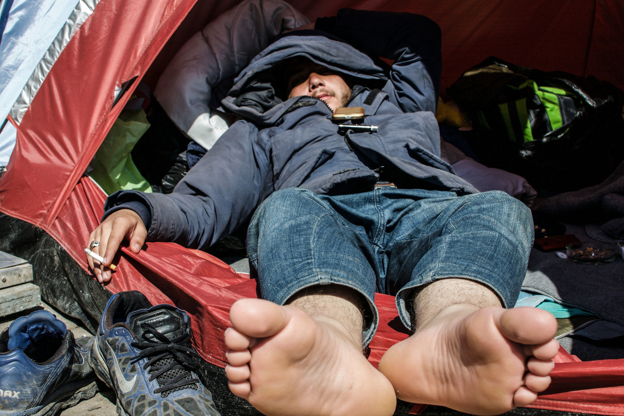 An Afghan teen relaxes in his tent listening to pop music.