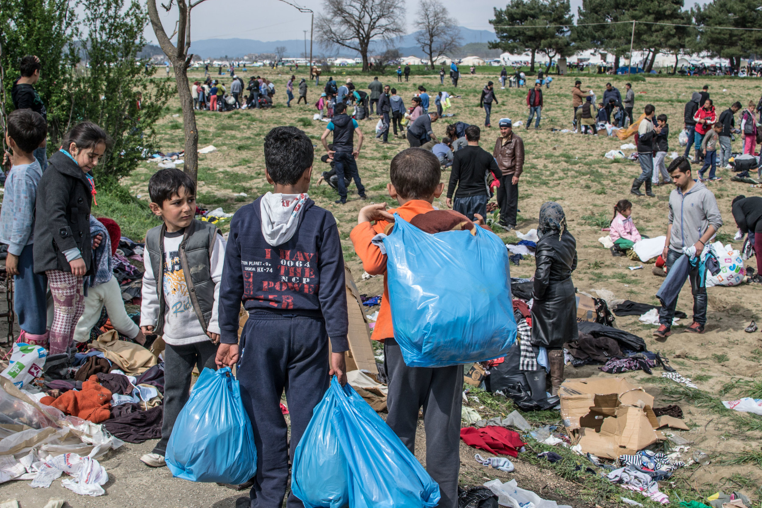 The aftermath of an unloading of used clothes from a truck; it was a desperate race for families to find sizes that fitted them all.