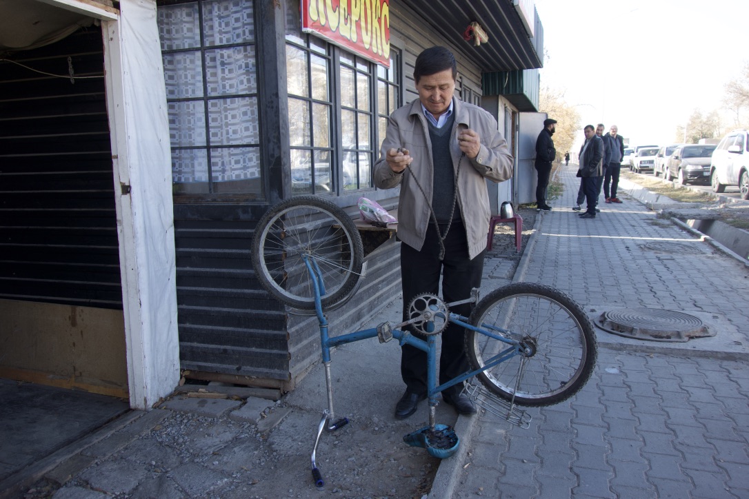  A local resident repairs repairs a bike outside of his shop. 