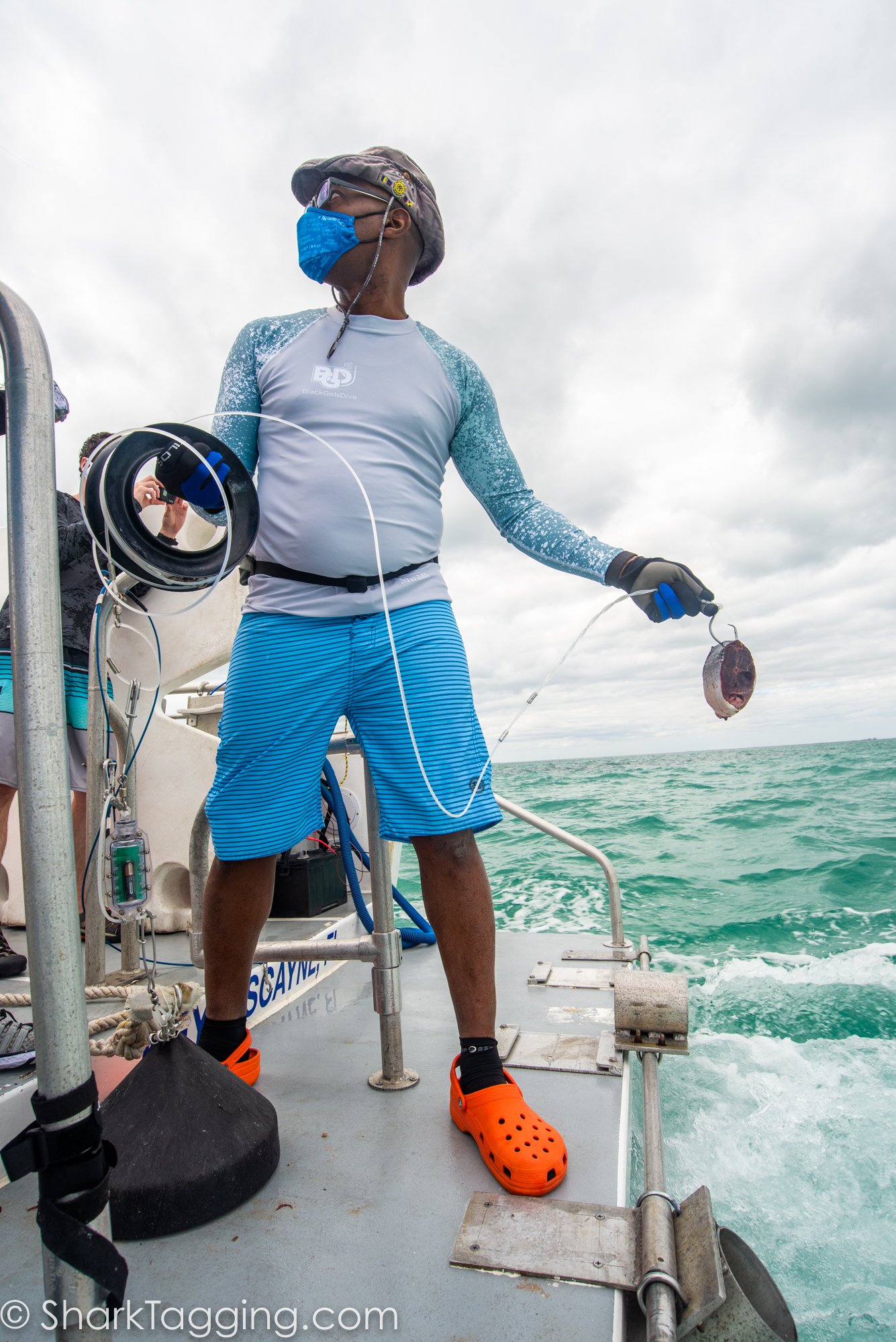 Instructor Johnson helps out and prepares to cast his line out to catch a shark