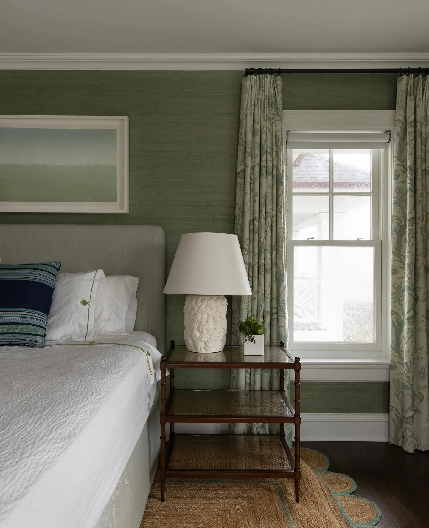 We love this green room at this ocean oasis. We layered in texture with the scalloped jute rug and textured grasscloth wallpaper. ⁠
Curtains and furniture by @brady.design 
Renovation work by @merrickconstructionco 
Paint and Paper by @pure_inc_